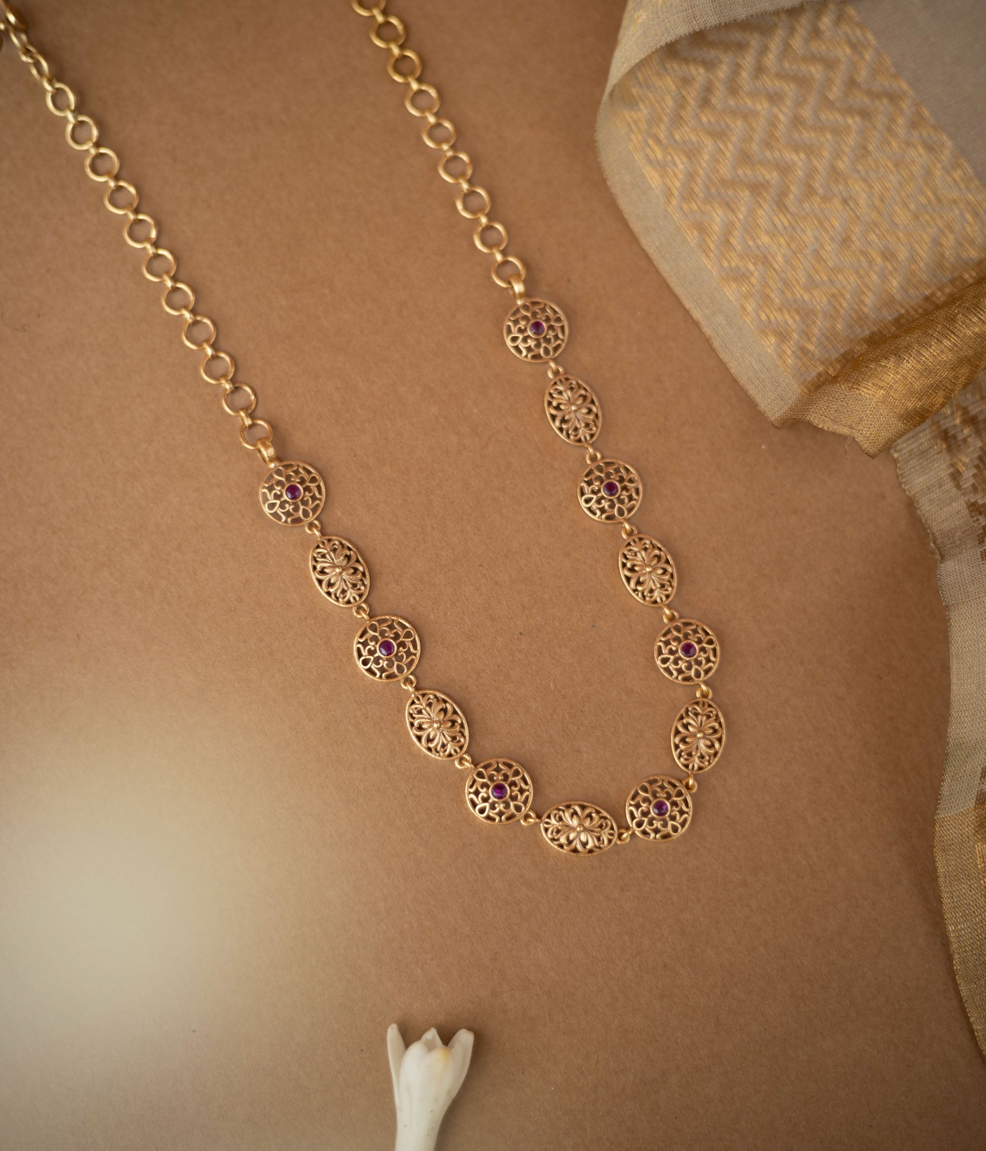 Antique gold necklace with red spinel stones in traditional circular and oval motifs.