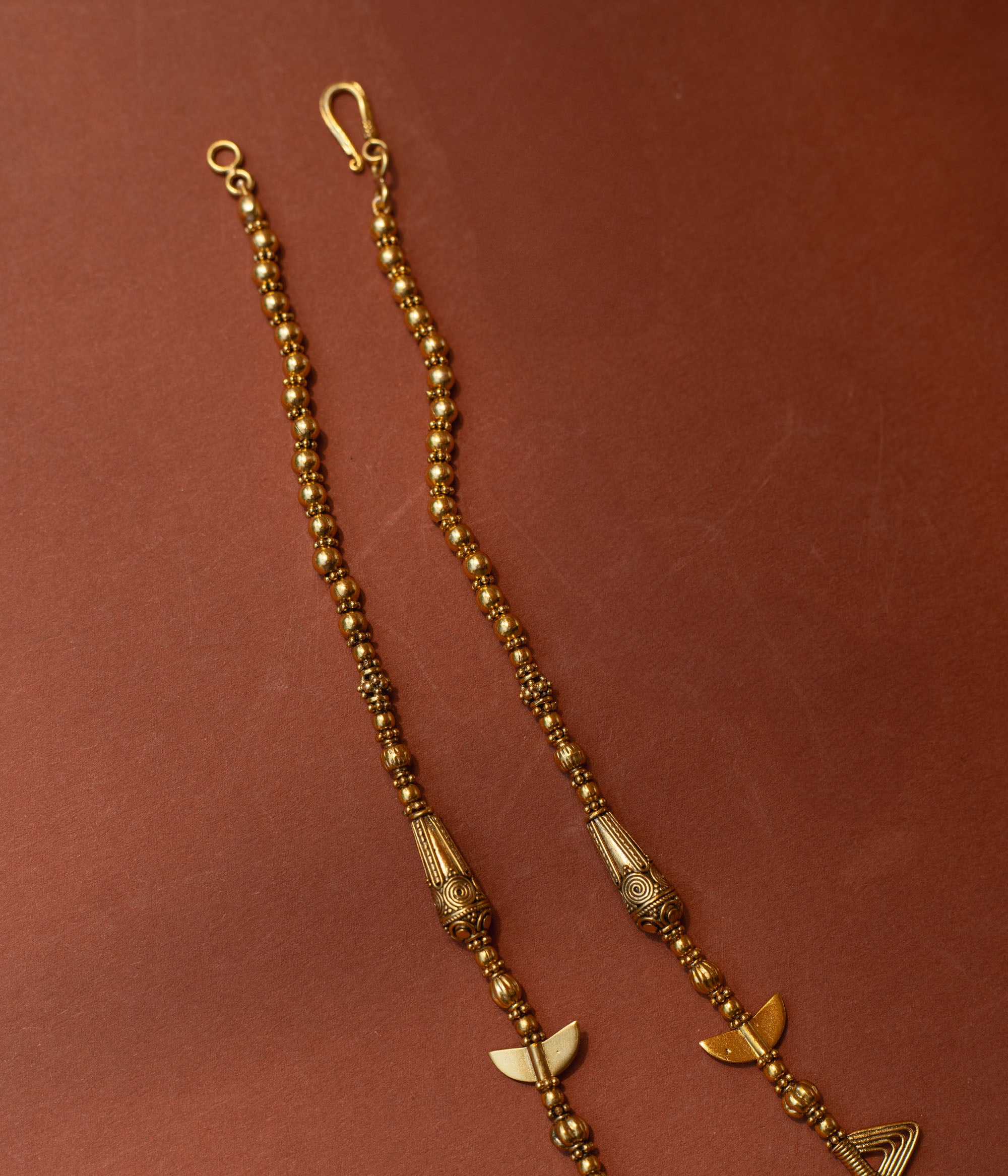 Traditional tribal gold necklace with temple motifs, half-moon shapes, and horn accents from Tribal Collection.