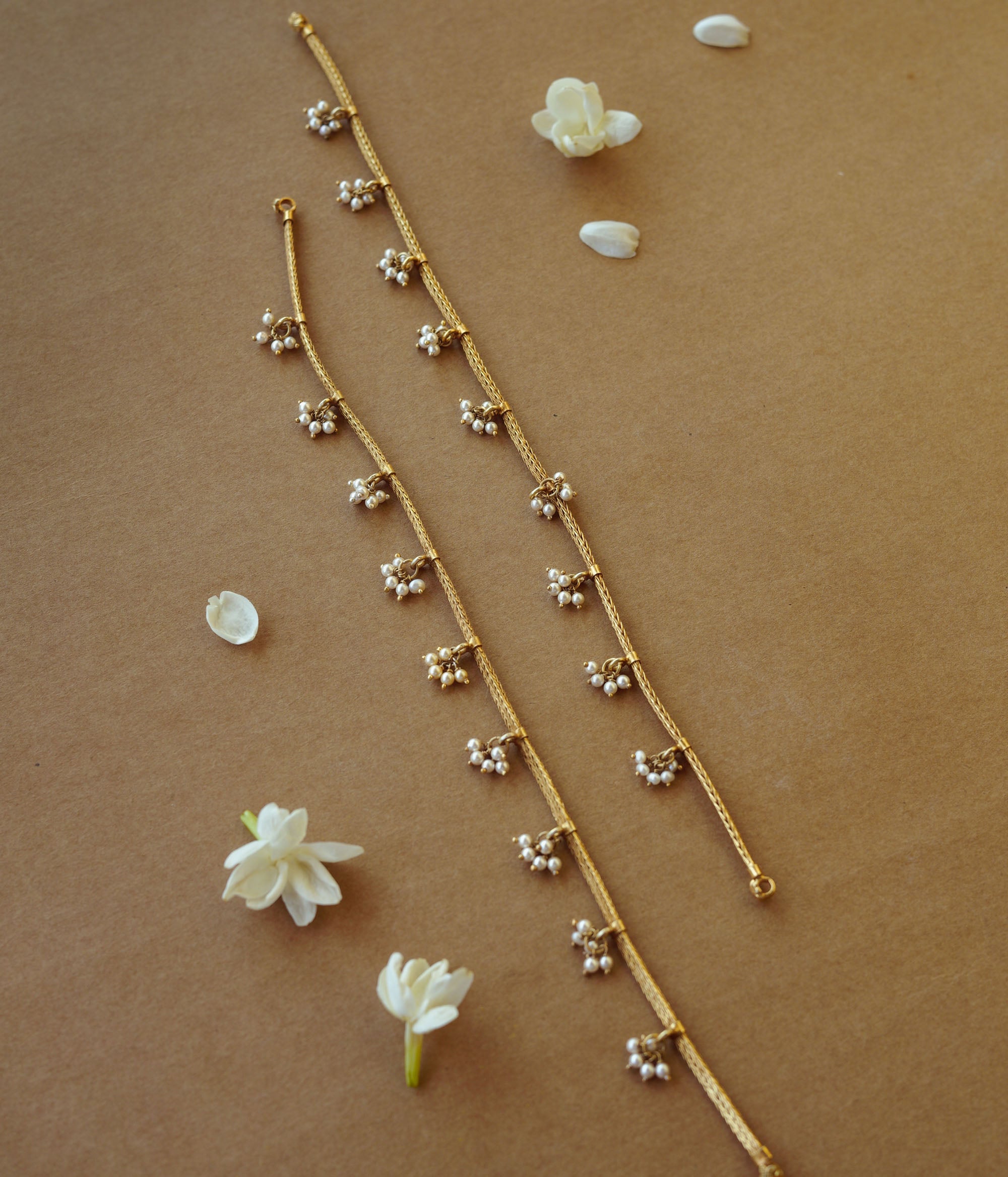 Golden tribal jasmine chain with pearl accents, nature-inspired jewelry, ethnic gold necklace design.