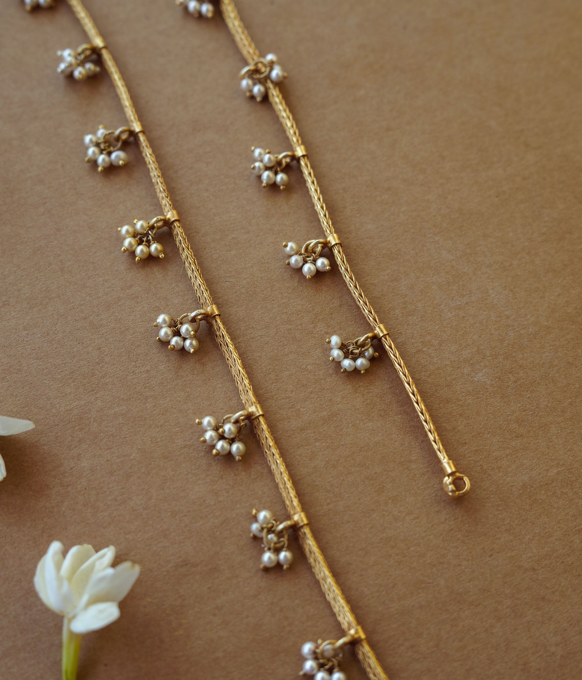 Golden tribal jasmine chain with pearl accents, nature-inspired jewelry, ethnic gold necklace design.