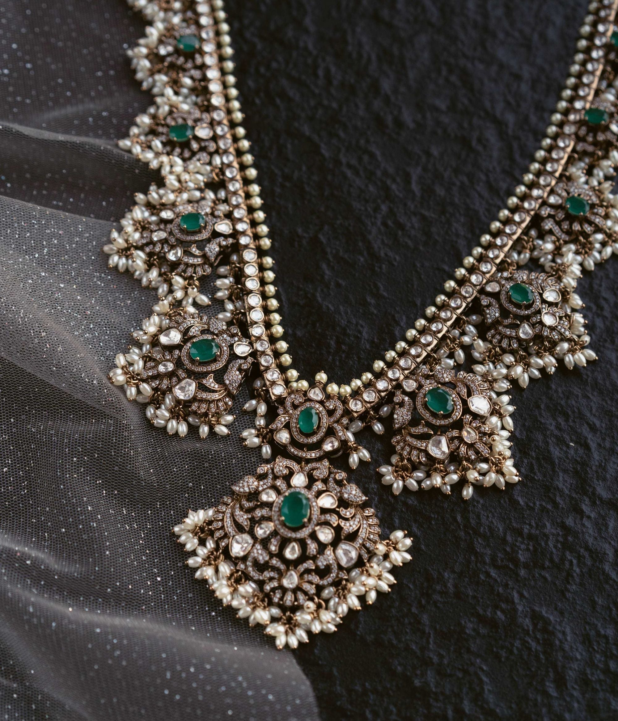 Opulent necklace adorned with Polki stones, CZ stones, duelite green stones, and white pearls, exuding timeless elegance and regal charm.