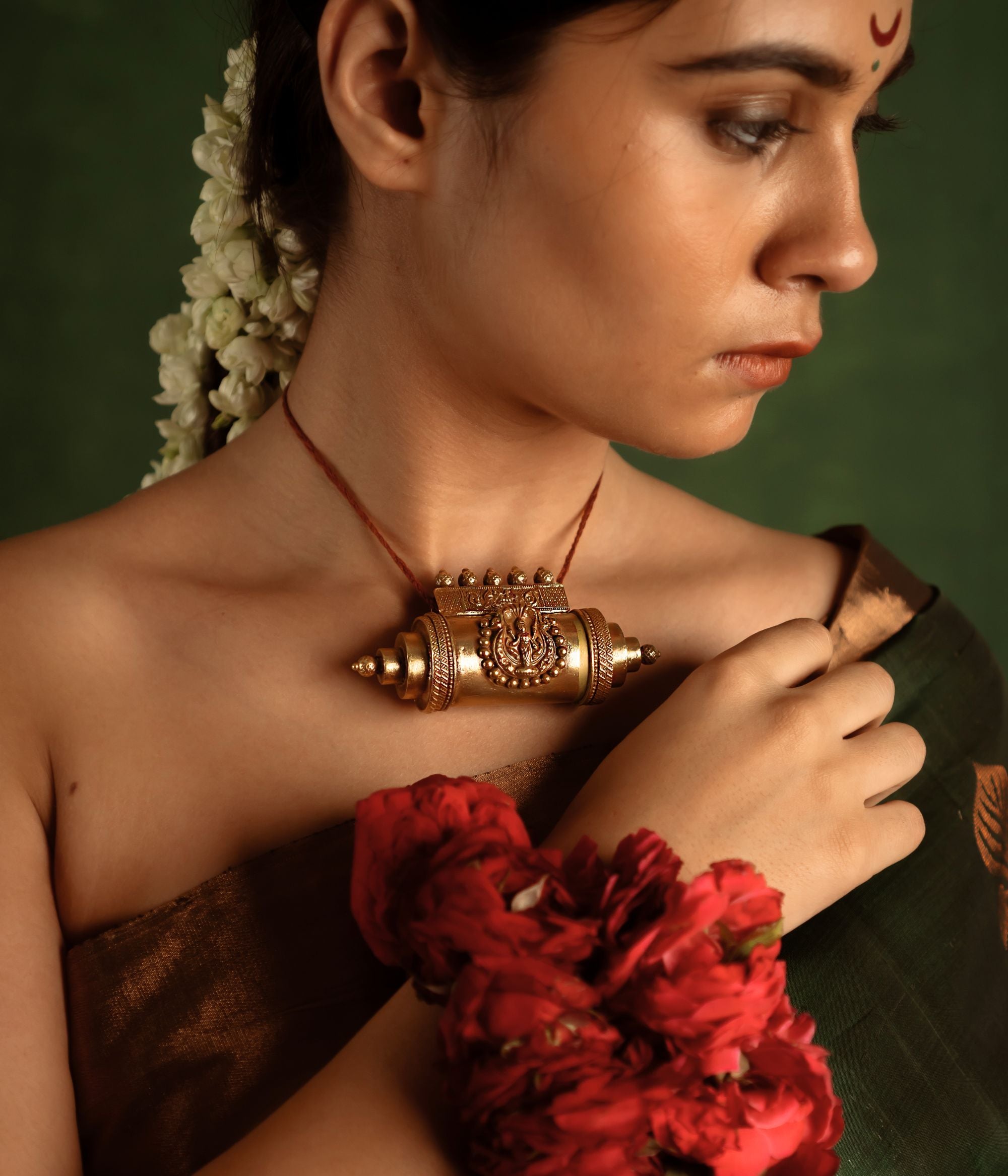 A bold statement of heritage, the Tabeez pendant with goddess motif stands as a symbol of individuality and divine grace. Crafted in gold, it commands attention with intricate deity details, celebrating Indian tradition.