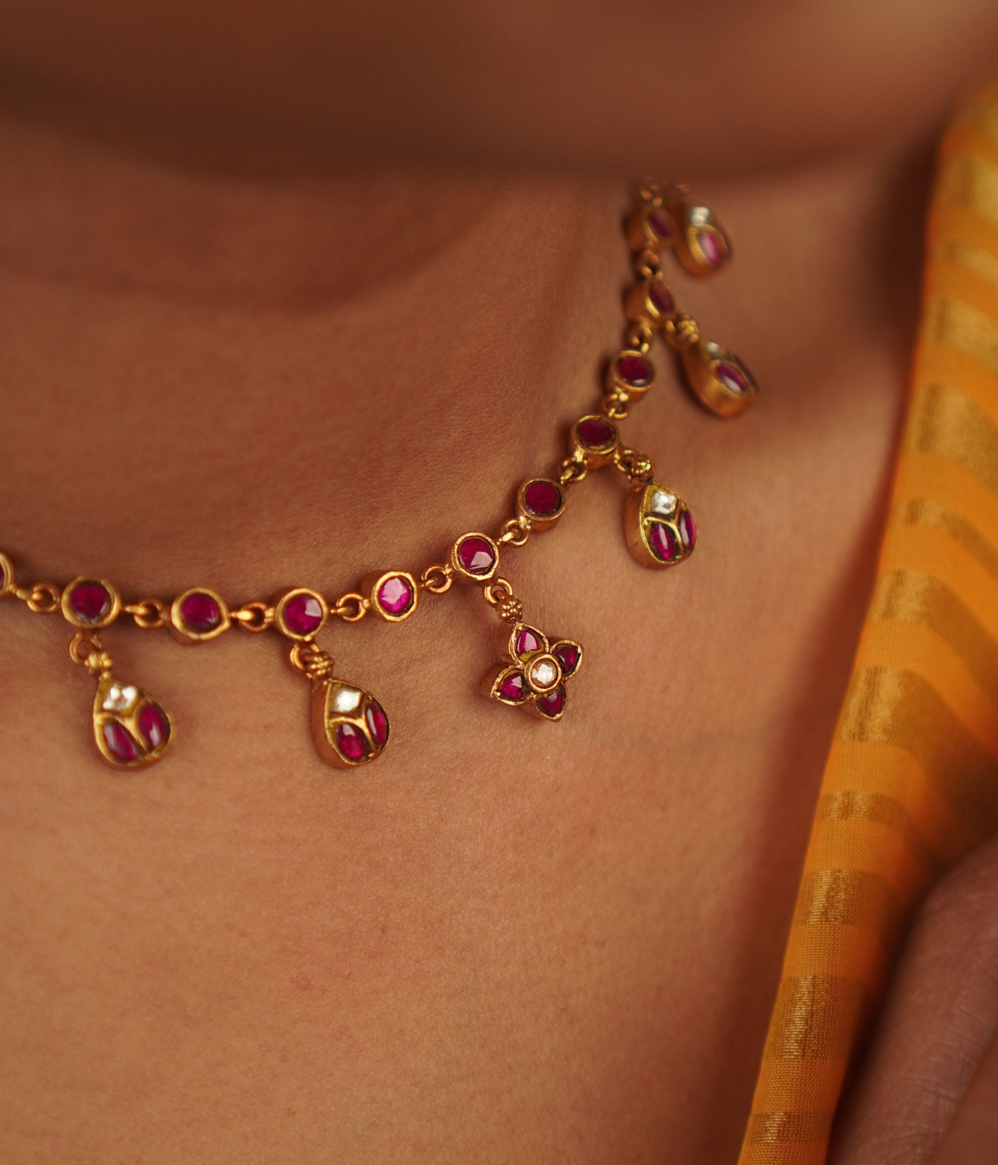 Timila Necklace: A blend of minimalism and vintage charm, this gold-plated silver piece features red Kundan, diamonds, and delicate floral motif droplets, creating a timeless elegance.