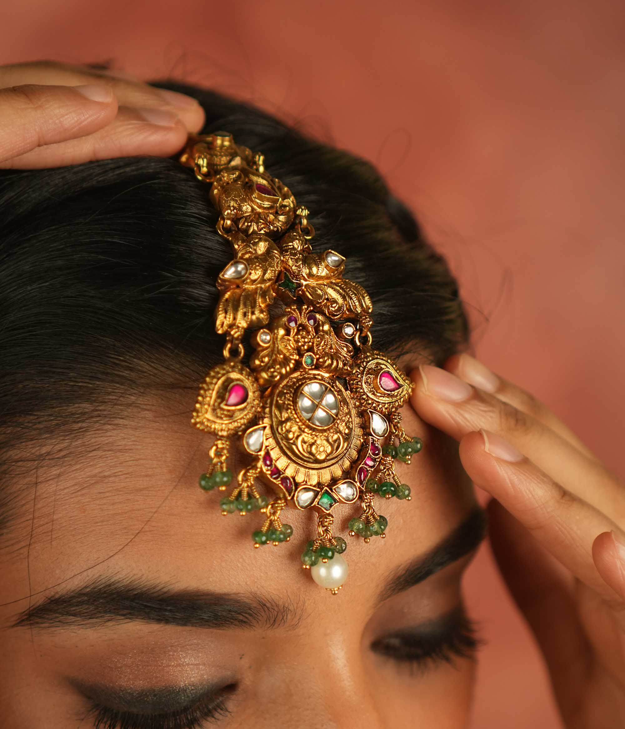 Regal whispers reimagined! A gold-plated maangtika adorned with peacock motifs, vibrant kundan, and delicate pearl droplets—a crown of divine elegance and timeless royalty.