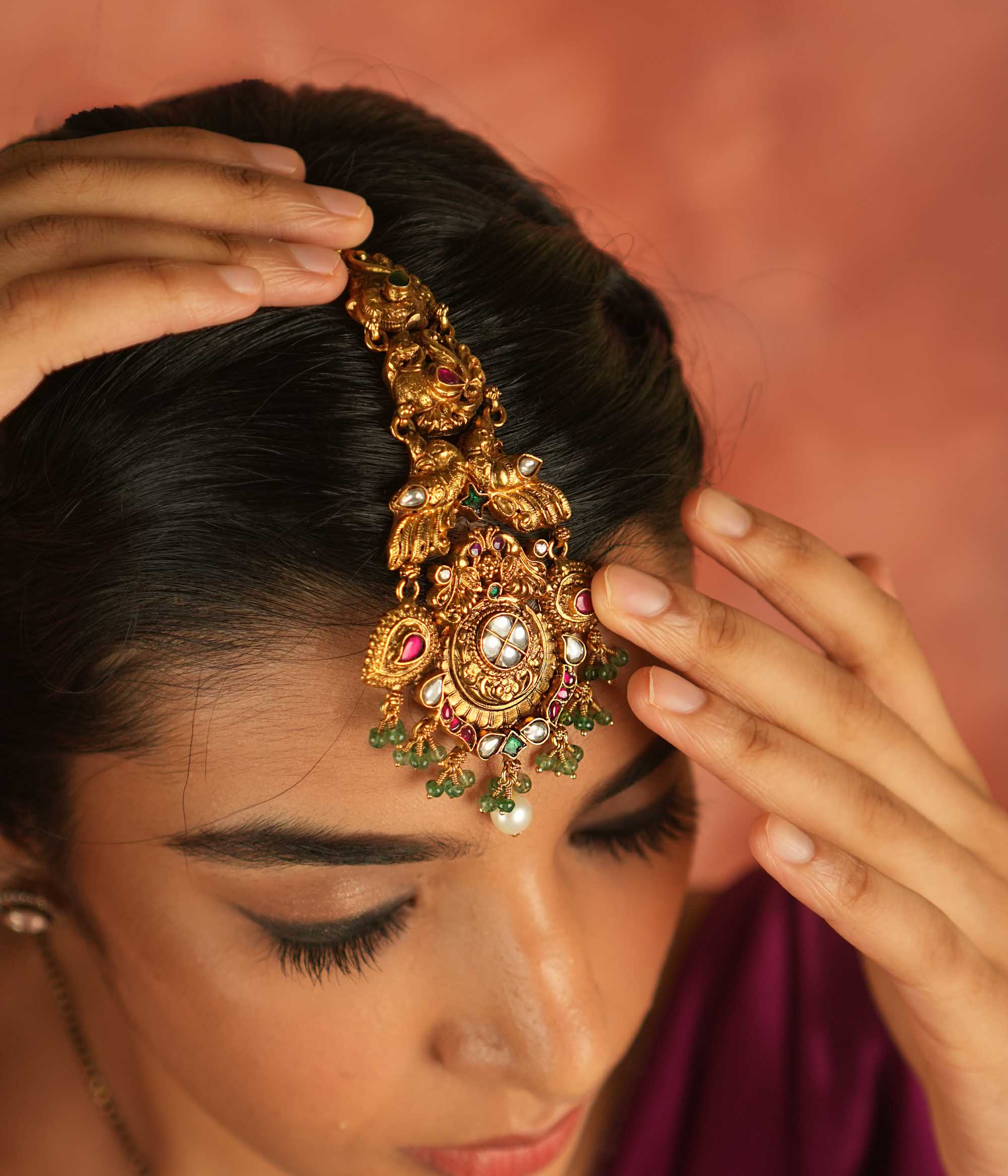Regal whispers reimagined! A gold-plated maangtika adorned with peacock motifs, vibrant kundan, and delicate pearl droplets—a crown of divine elegance and timeless royalty.