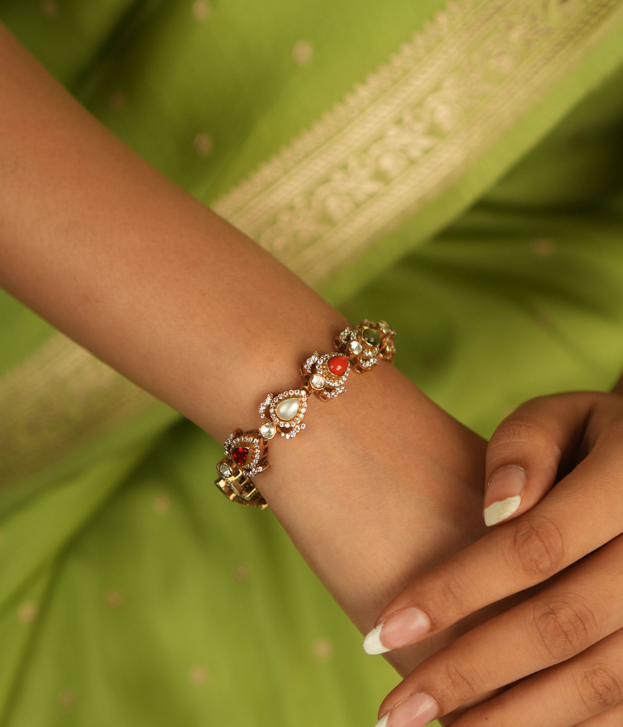 Celestial whispers reborn! This gold-plated bracelet, adorned with vibrant Navaratna stones encircled by shimmering CZ, weaves ancient wisdom with modern elegance—a cosmic symphony for the modern woman.