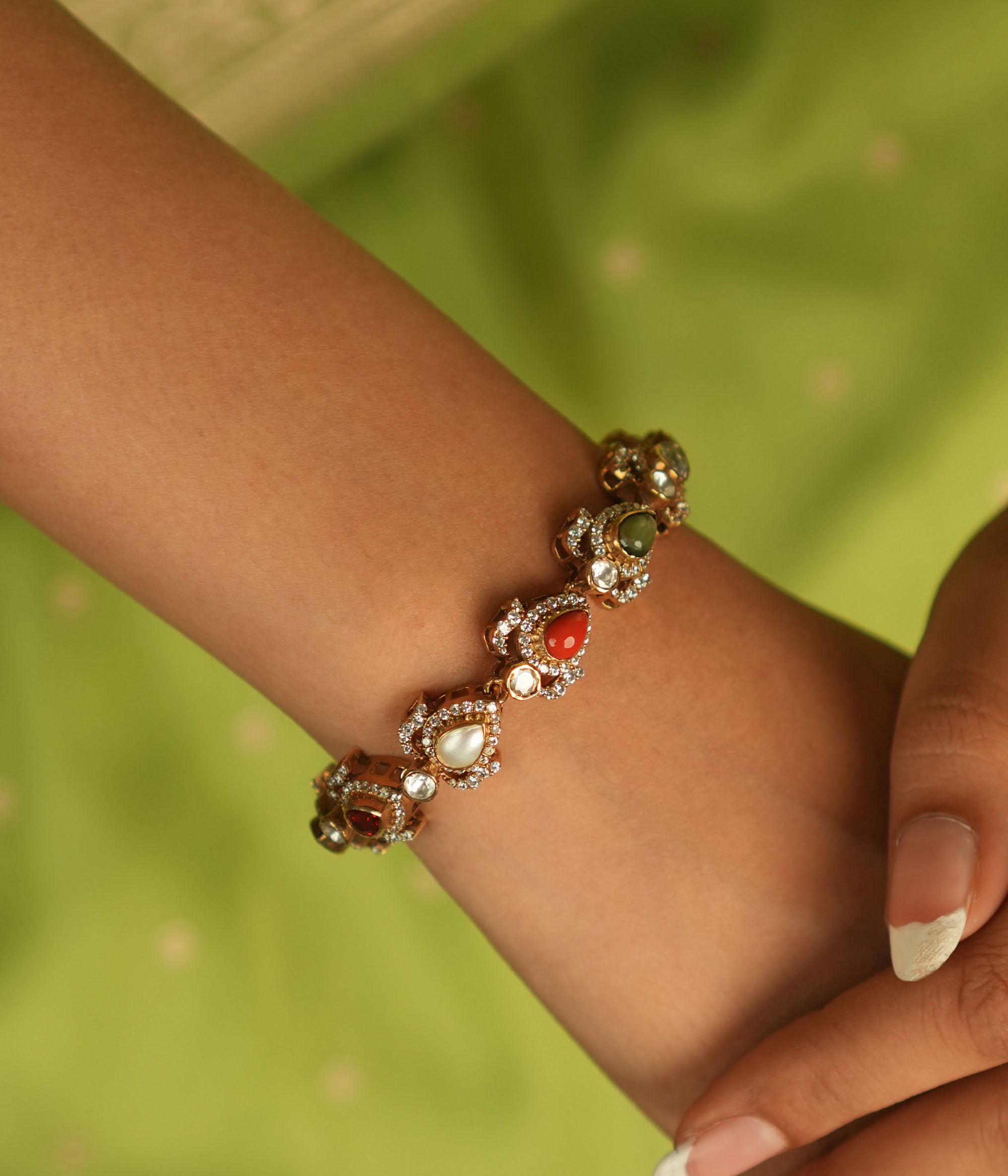 Celestial whispers reborn! This gold-plated bracelet, adorned with vibrant Navaratna stones encircled by shimmering CZ, weaves ancient wisdom with modern elegance—a cosmic symphony for the modern woman.
