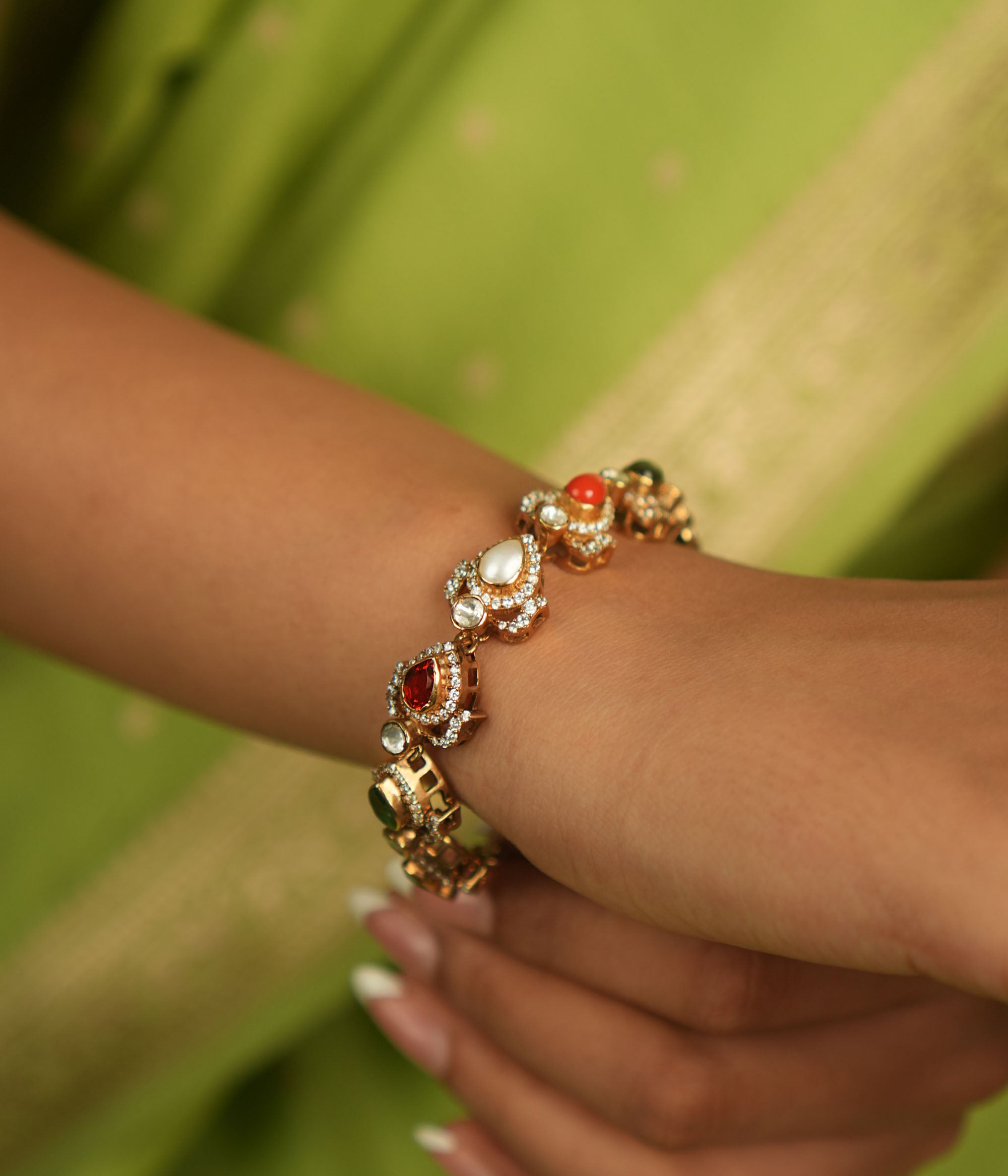 Celestial whispers reborn! This gold-plated bracelet, adorned with vibrant Navaratna stones encircled by shimmering CZ, weaves ancient wisdom with modern elegance—a cosmic symphony for the modern woman.