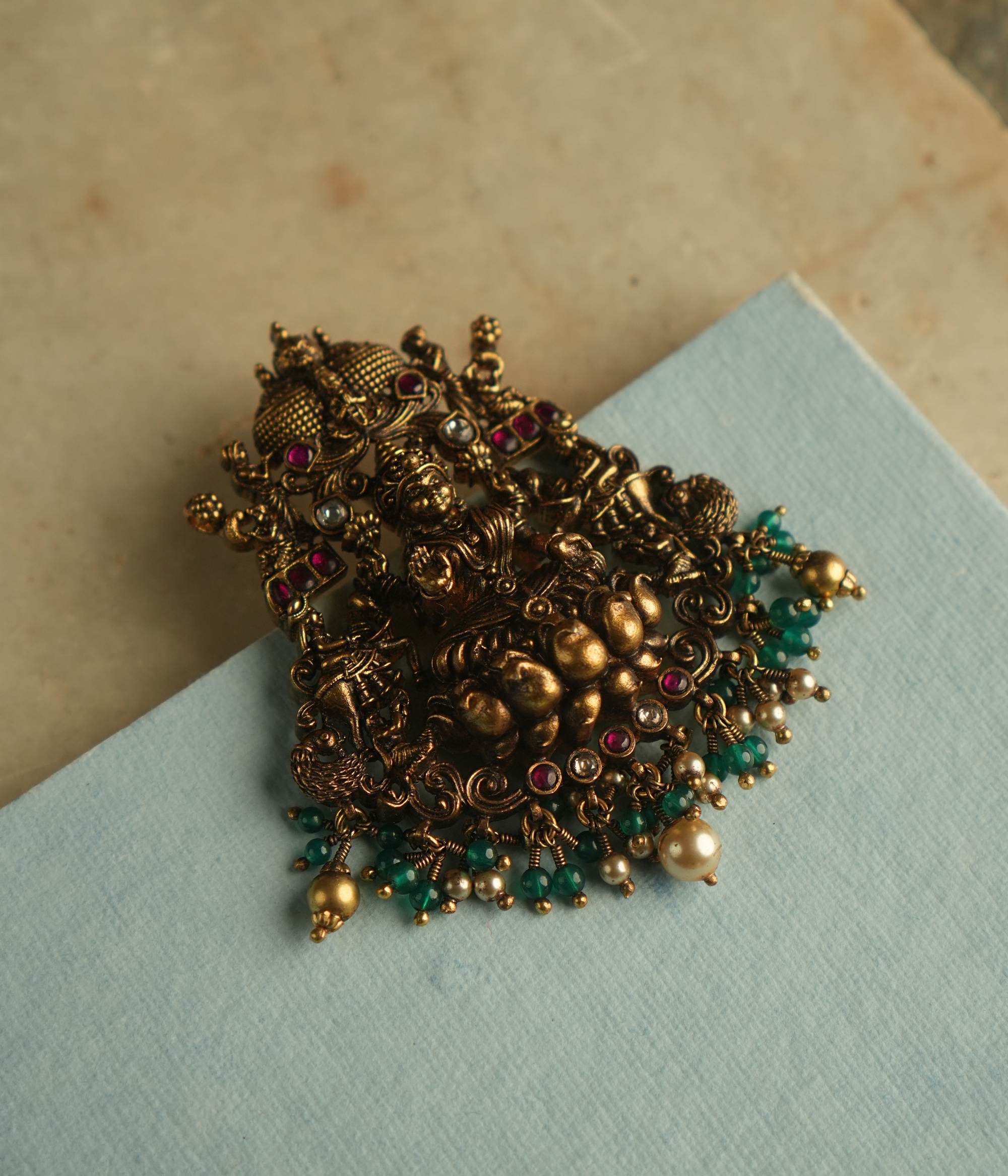 Adorn yourself with serenity and timeless elegance with our exquisite Nakshi pendant, featuring a divine Goddess Lakshmi motif, intricately crafted with red and white Kundan stones. A true symbol of grace and heritage.