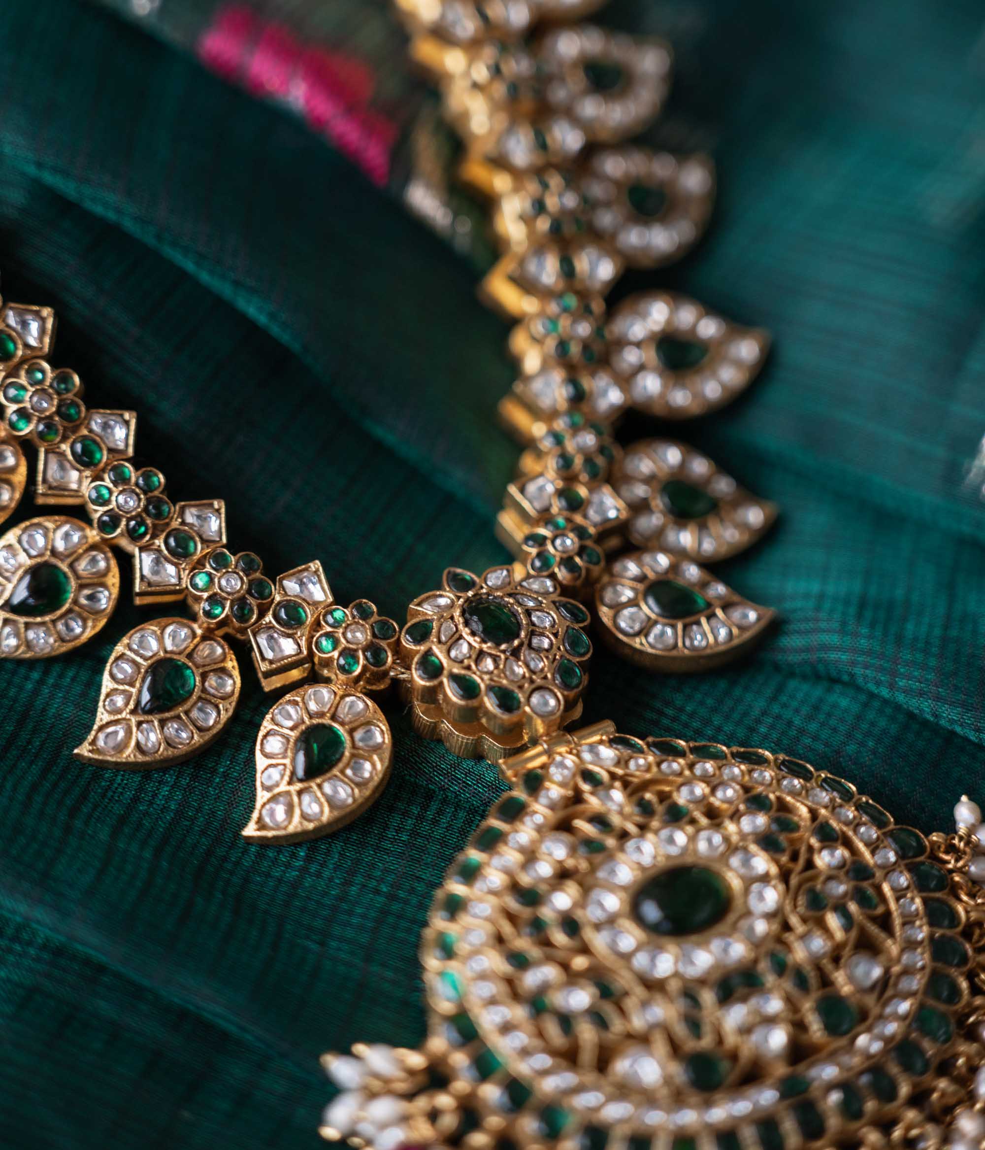A handcrafted two-sided Kundan necklace in 92.5 sterling silver with 22ct gold plating, adorned with red, white, and green Kundan stones, red beads, and pearls. This versatile masterpiece exudes timeless elegance, blending heritage craftsmanship with regal charm.