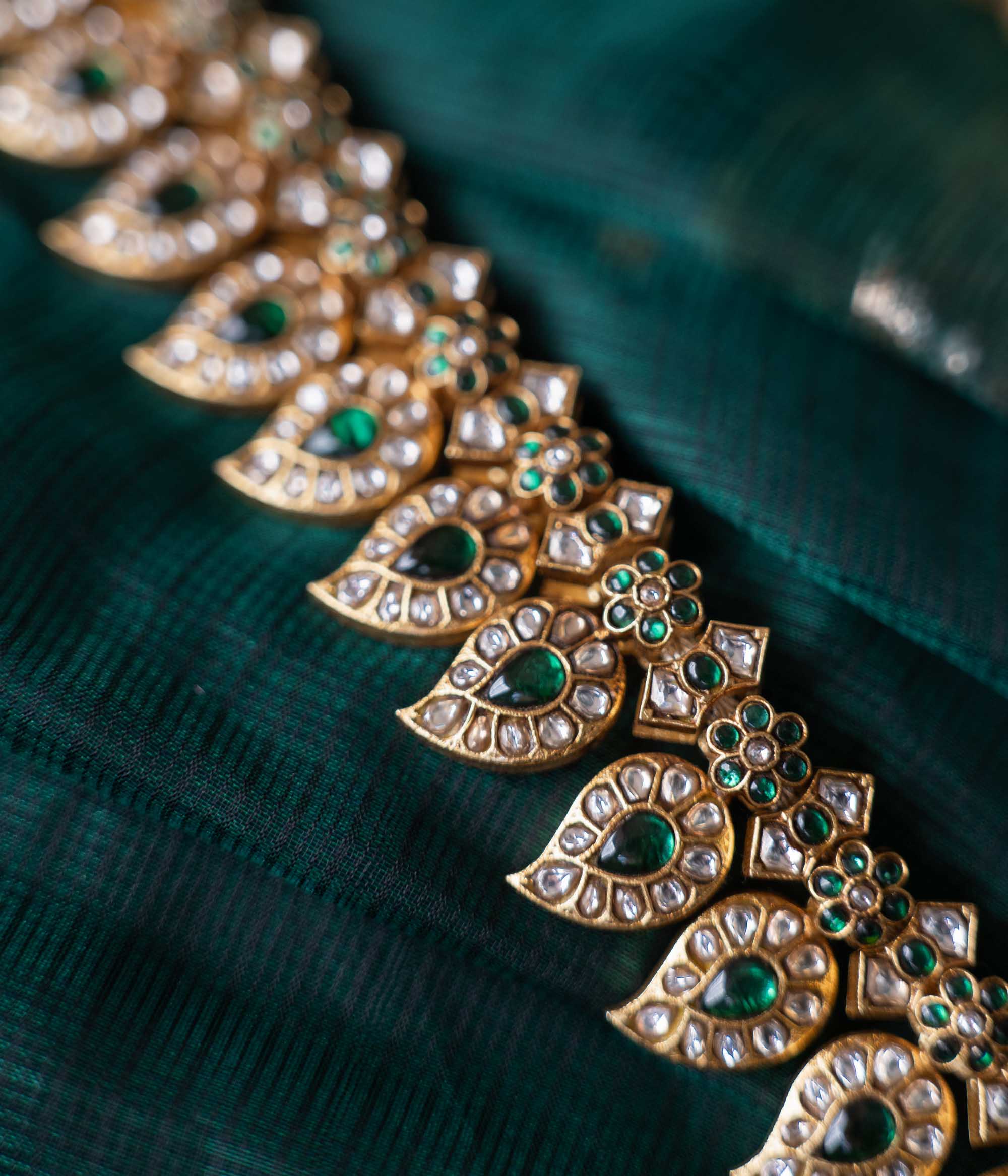 A handcrafted two-sided Kundan necklace in 92.5 sterling silver with 22ct gold plating, adorned with red, white, and green Kundan stones, red beads, and pearls. This versatile masterpiece exudes timeless elegance, blending heritage craftsmanship with regal charm.
