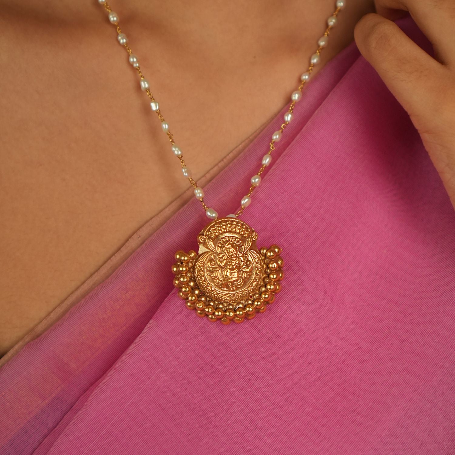 Amidst the weave of tradition and modernity, this gold-plated silver temple pendant with a goddess motif and golden beads radiates timeless allure.