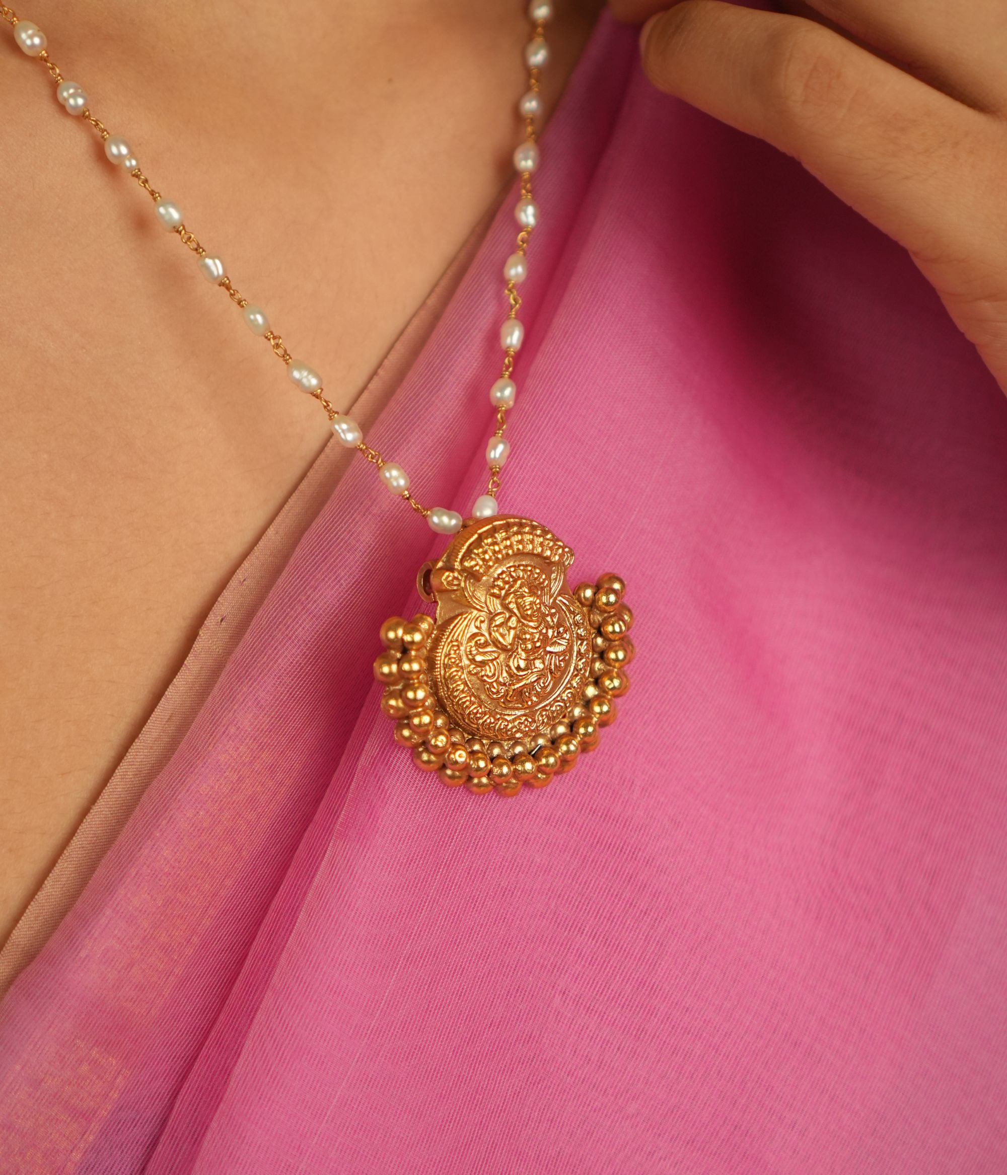 Amidst the weave of tradition and modernity, this gold-plated silver temple pendant with a goddess motif and golden beads radiates timeless allure.
