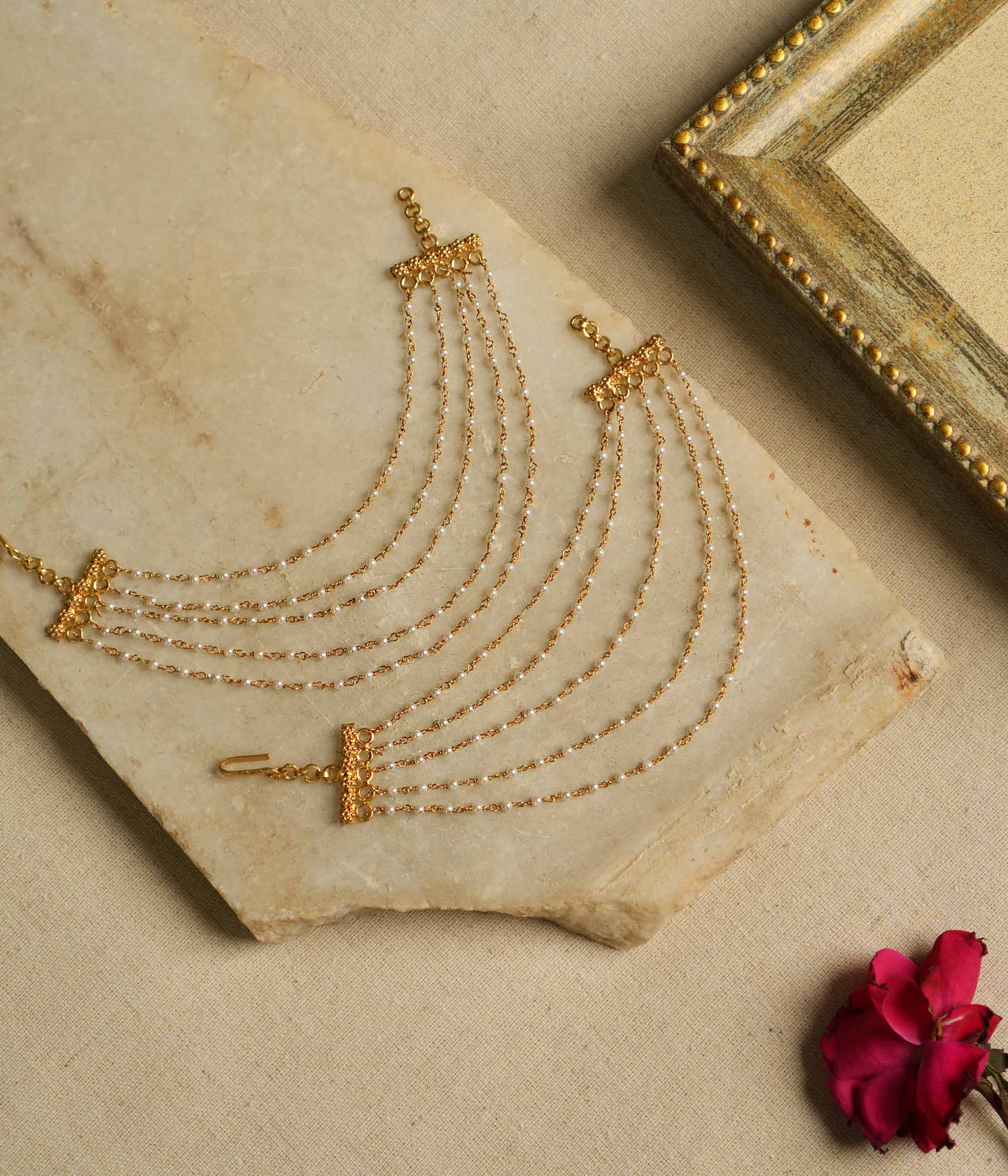 Ethereal grace reborn! This delicate gold-plated pearl ear chain exudes timeless elegance, with lustrous pearls linked in a graceful flow. A blend of heritage and sophistication, it beautifully complements any traditional or modern ensemble, making it a treasured adornment for every occasion.