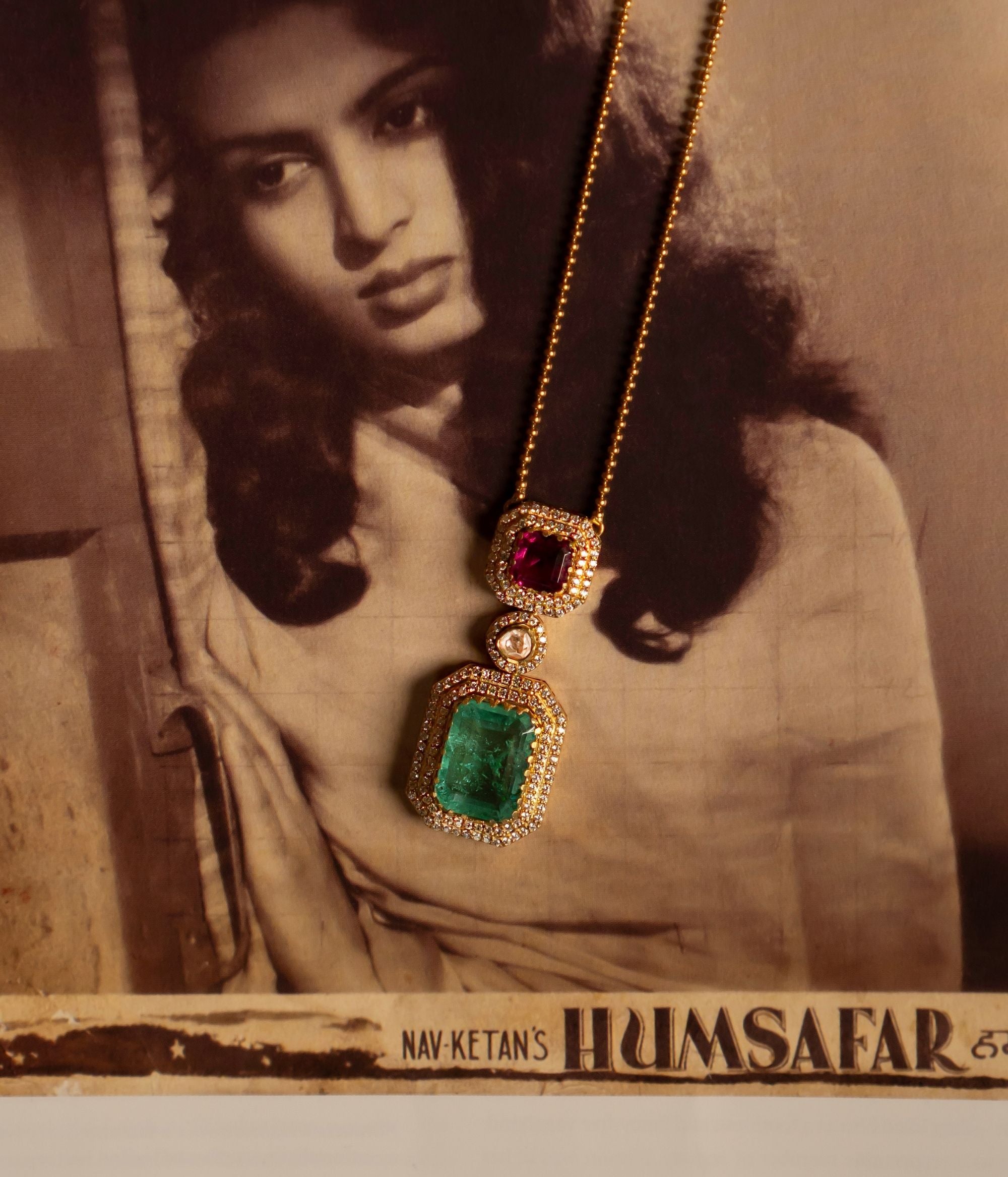 A delicate gold-plated silver jewelry piece featuring a dainty golden beaded chain with an attached pendant. The pendant showcases a captivating Pink Tourmaline stone encircled by shimmering CZ stones, complemented by a drop of Green Tourmaline elegantly surrounded by CZ stones. At the center, a radiant Moissanite Polki stone enhances the design, adding a touch of sophistication. This finely crafted piece exudes elegance and charm, making it a timeless addition to any collection.