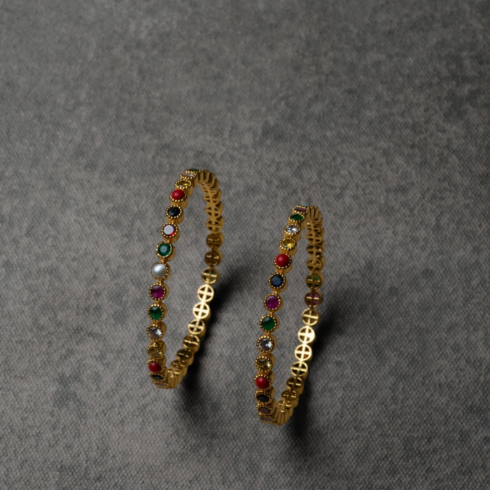 A Navratna bangle featuring nine vibrant gemstones, each symbolizing a celestial body, designed to bring good fortune and positive energy. Its exquisite charm adds both beauty and spiritual significance to any look.
