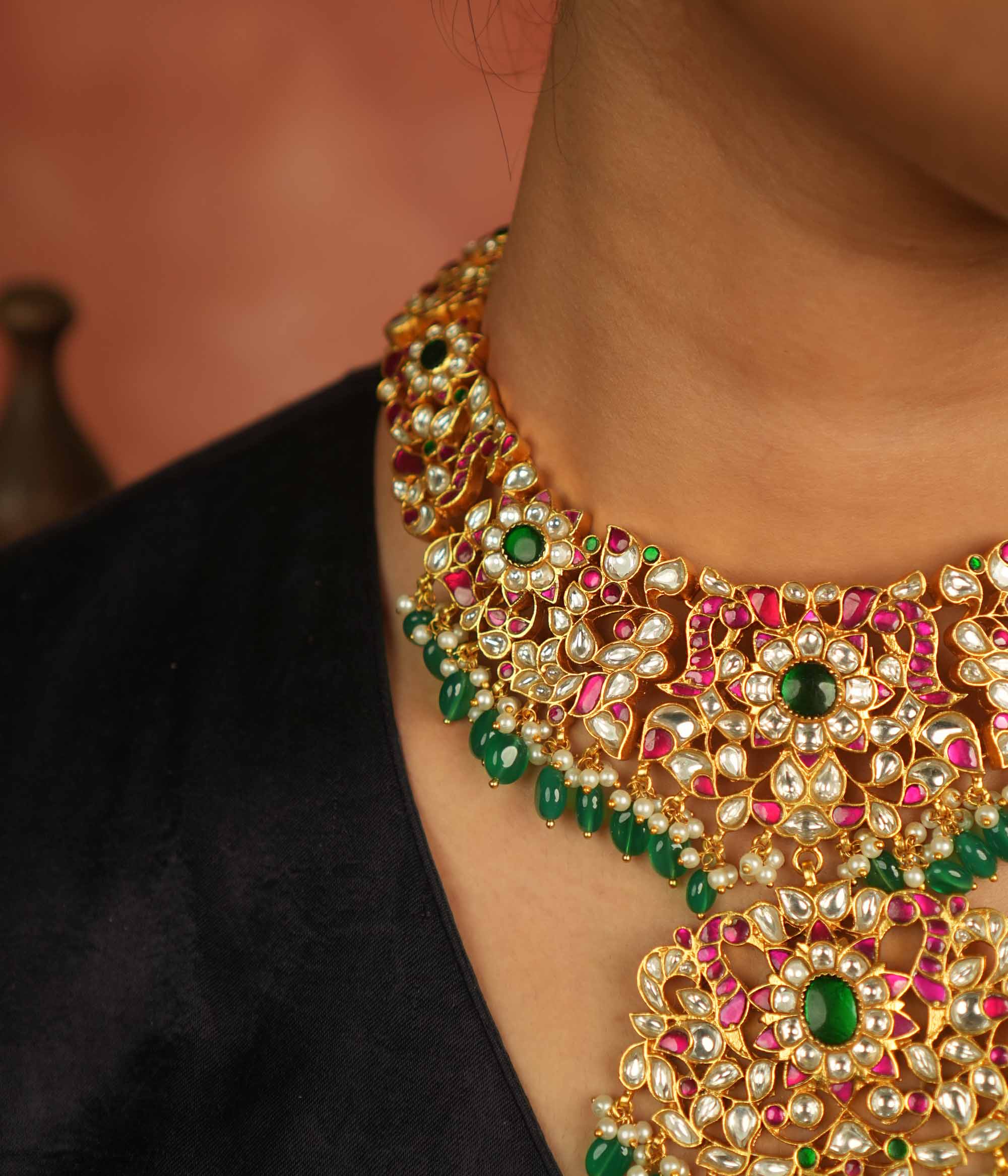 Temple whispers reborn! Antique gold necklace adorned with floral motifs, where kundan, pearls, and green beads evoke divine splendor and timeless elegance.