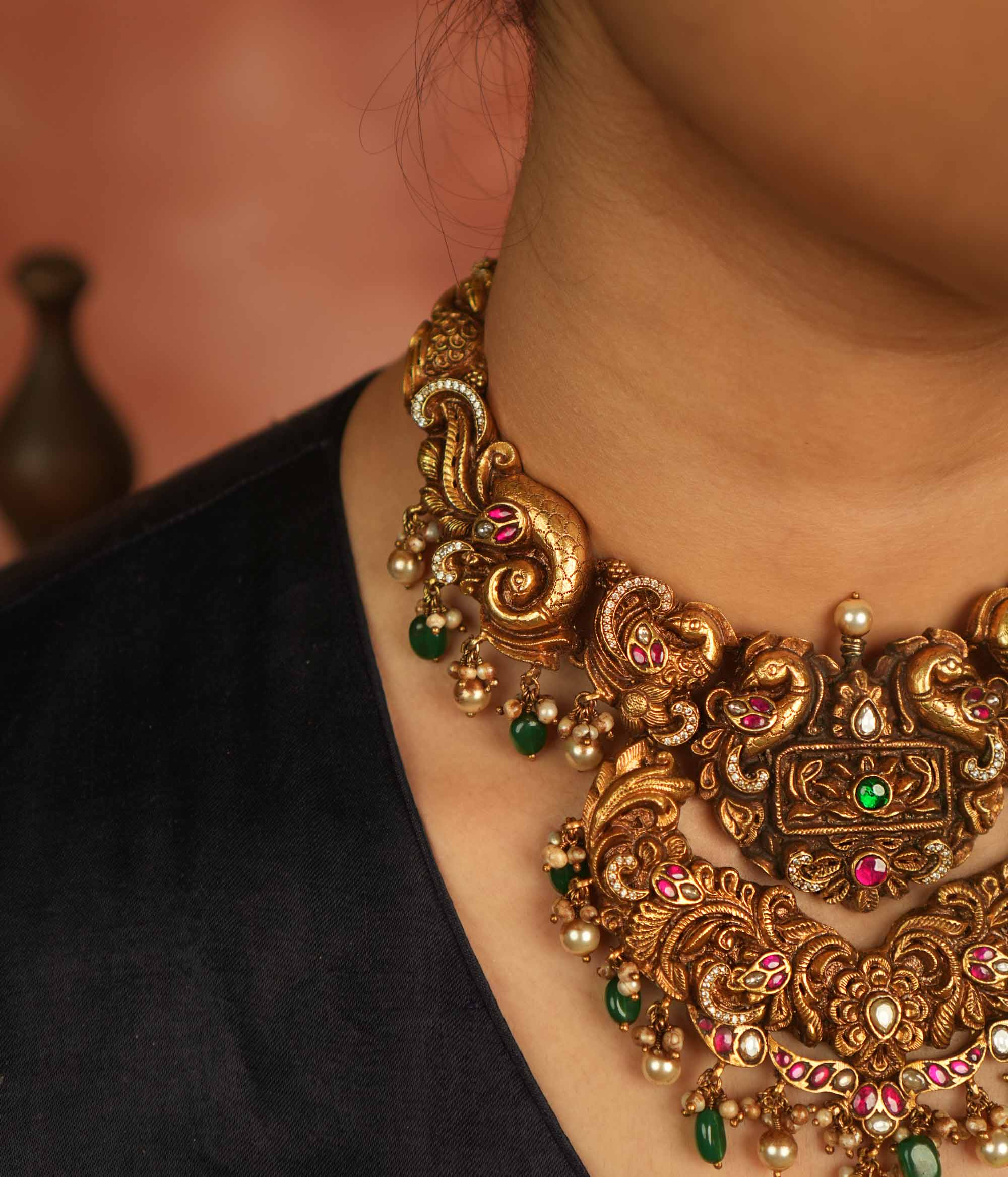 Temple whispers reborn! Antique gold necklace adorned with peacock and floral motifs, where kundan, pearls, and green beads evoke divine splendor and timeless elegance.