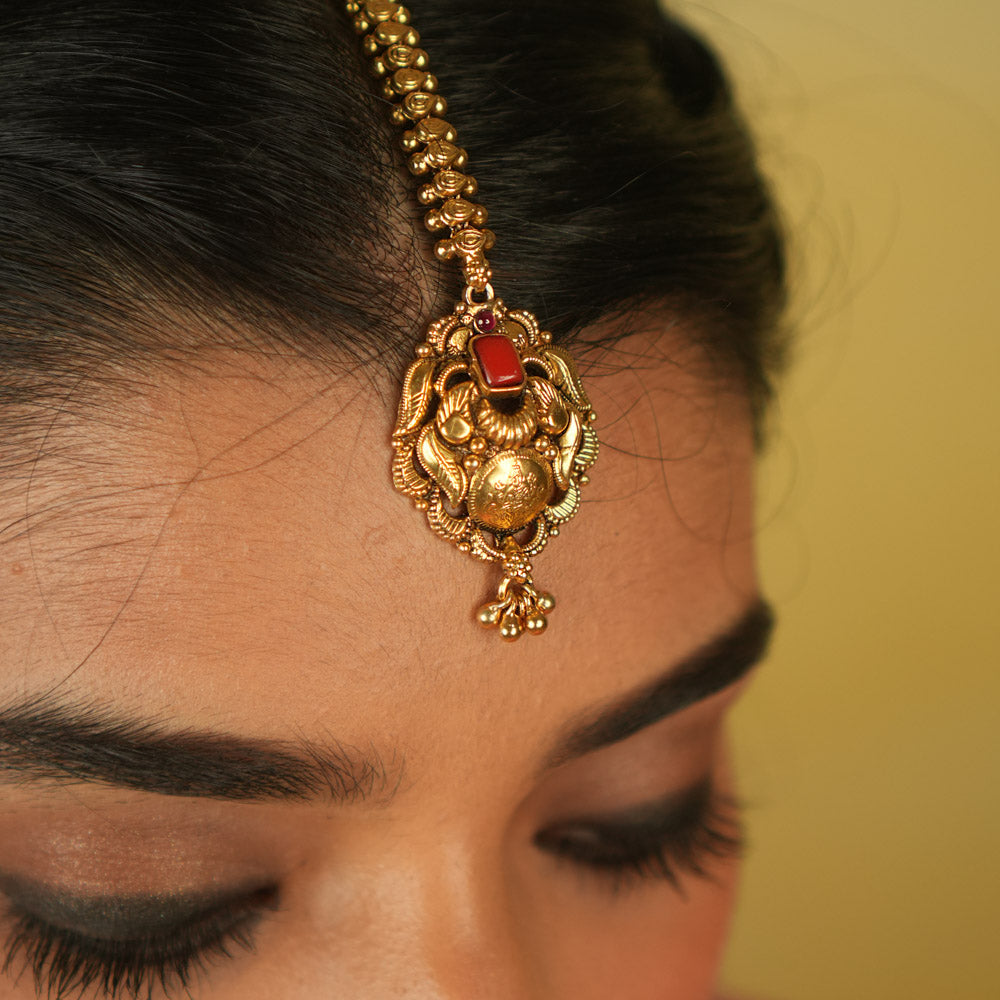 Temple grace reimagined. Gold-plated maangtika with radiant red spinel bridges earthly elegance with divine splendor.