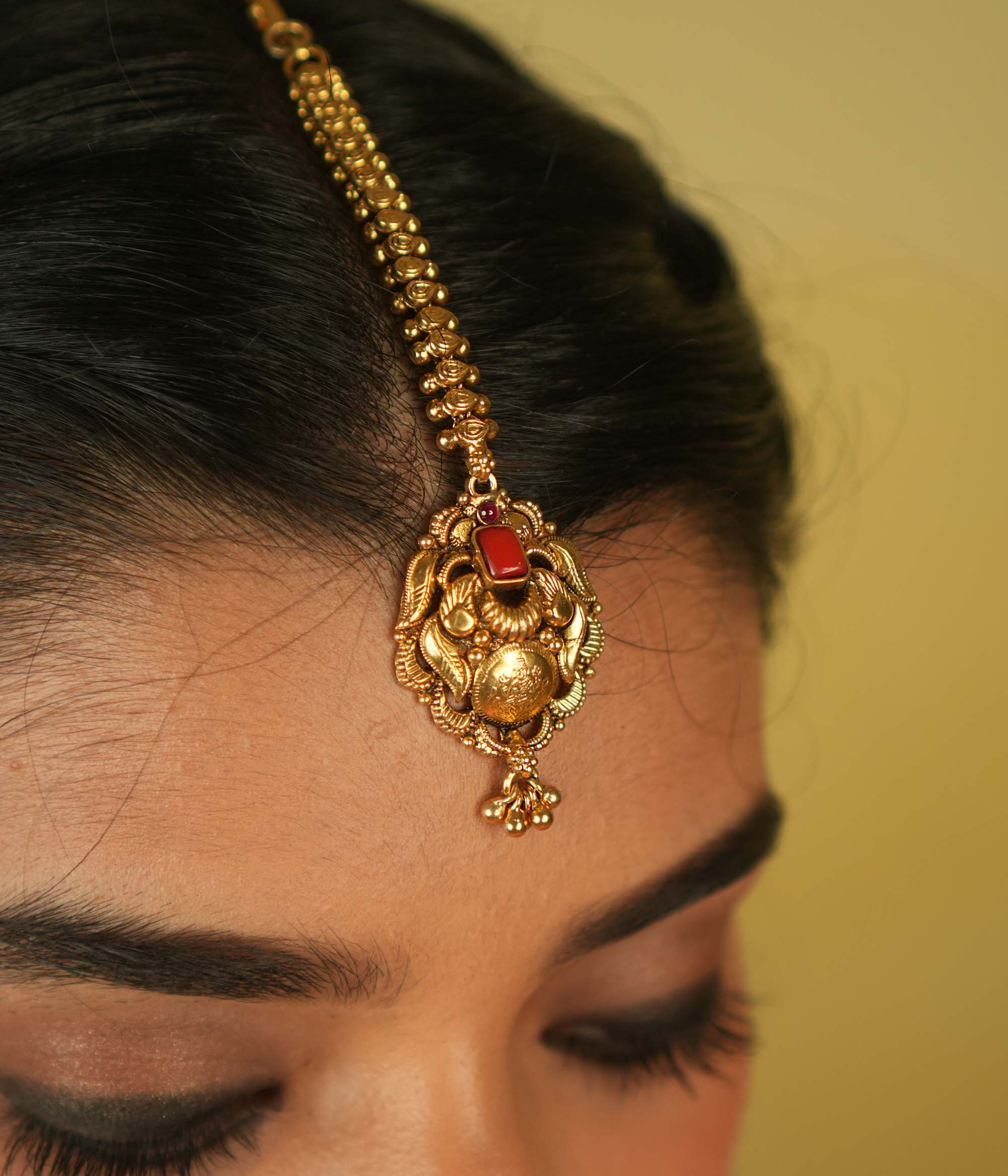 Temple grace reimagined. Gold-plated maangtika with radiant red spinel bridges earthly elegance with divine splendor.