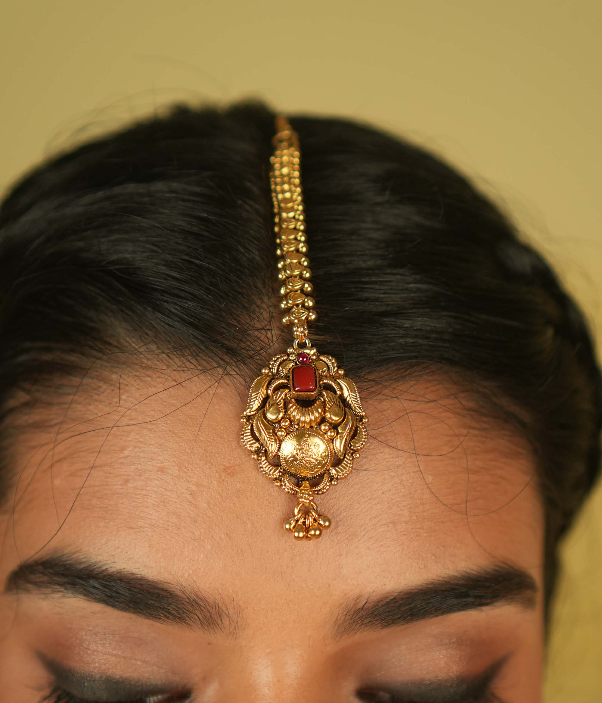 Temple grace reimagined. Gold-plated maangtika with radiant red spinel bridges earthly elegance with divine splendor.