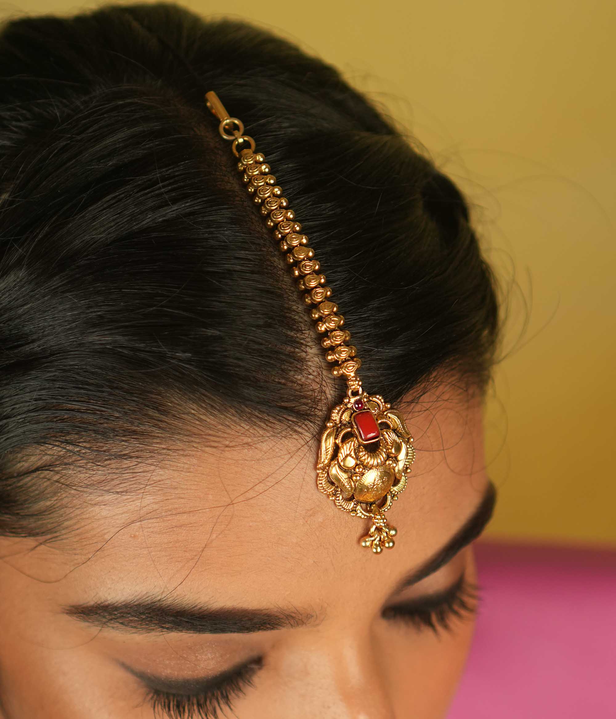 Temple grace reimagined. Gold-plated maangtika with radiant red spinel bridges earthly elegance with divine splendor.