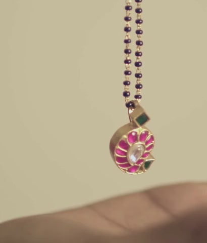 Close-up of handcrafted Avni mangalsutra pendant with multicolor kundan stones and black beads