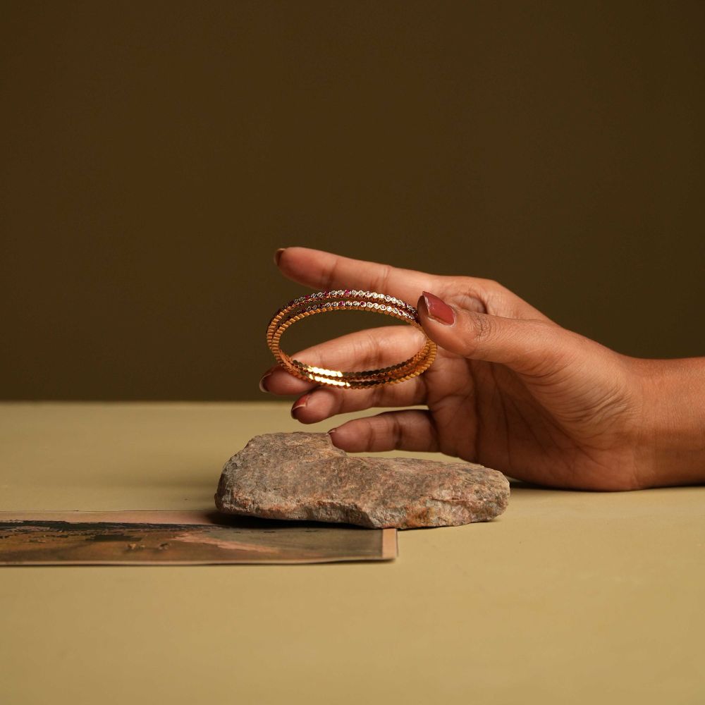 A delicate 92.5 sterling silver bangle featuring moissanite and red gemstones in a single line, inspired by classic Chettinad stone settings and exuding understated luxury.