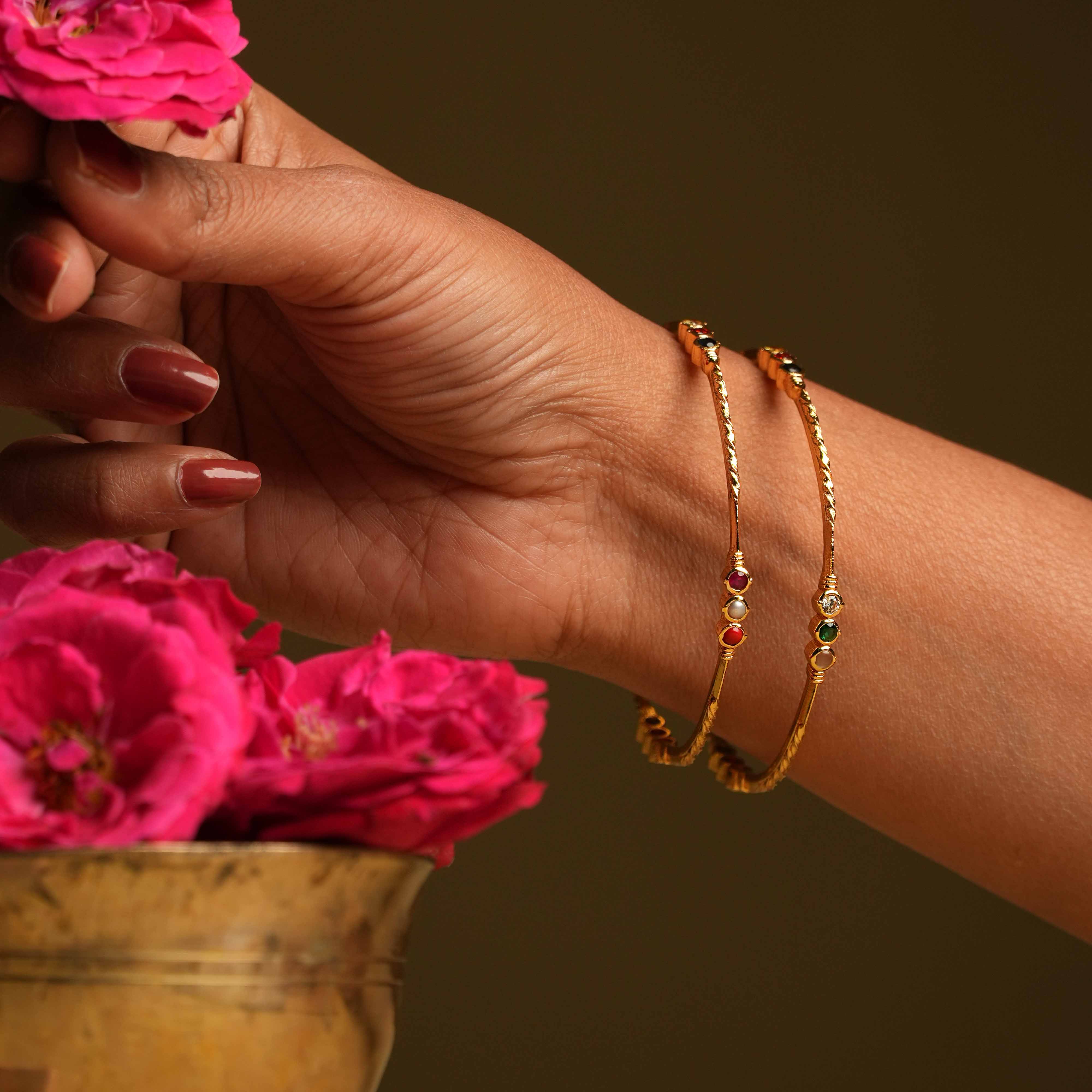 A minimal 92.5 sterling silver and 22 carat gold-plated bangle featuring clusters of delicate round-cut navratna and CZ stones, evoking the ancient mystique of nine sacred gemstones.