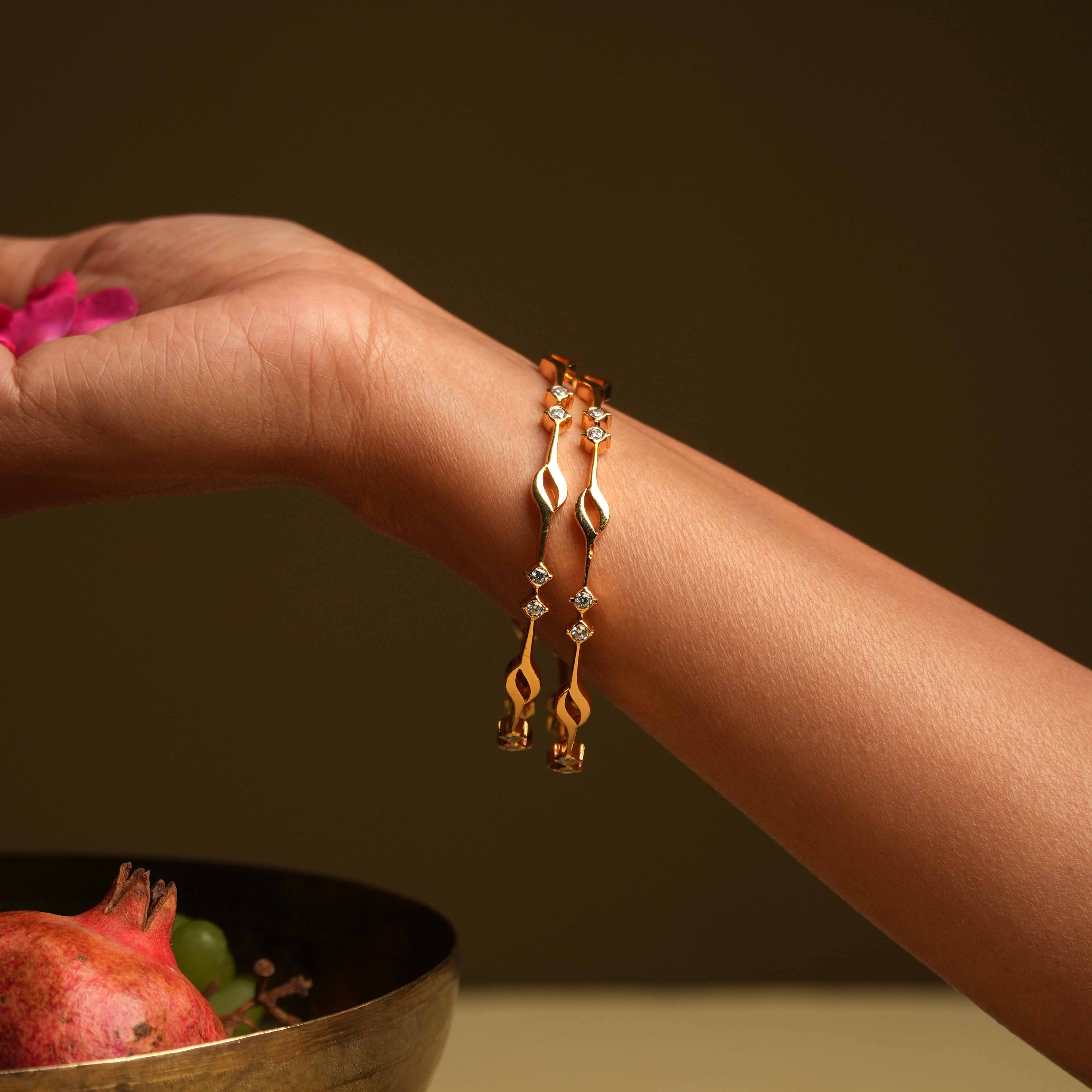 A minimalist 92.5 sterling silver bangle with an insert closure, featuring two square-cut Swarovski stones arranged at intervals, evoking the classic sophistication of traditional diamond settings.
