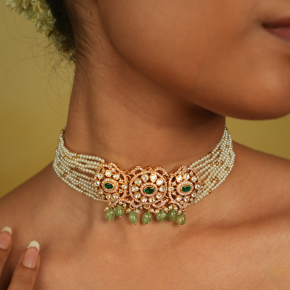 Floral whispers come alive in this exquisite choker, featuring a delicate pearl chain, Moissanite Polki stones, CZ stones, green cut stones, green beads, and pearls. A celestial symphony of opulence and romance, this piece exudes timeless elegance, making it a perfect choice for the discerning connoisseur.