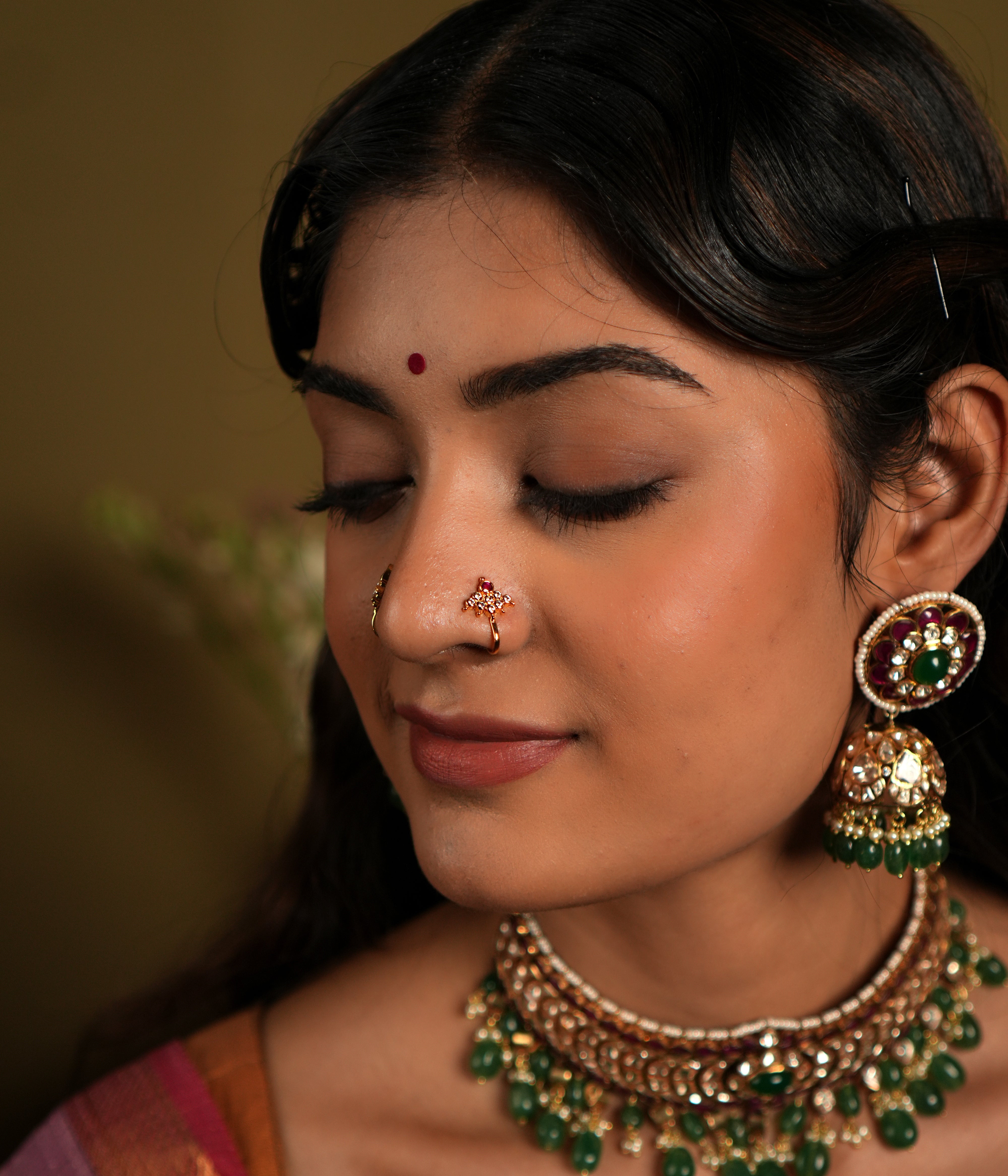 features a beautiful 92.5 sterling silver nose pin with an elegant gold-plated finish. The nose pin showcases intricate craftsmanship with a vibrant arrangement of colored stones, adding a touch of tradition and sophistication. Perfect for both daily wear and special occasions, this nose pin combines cultural elegance with contemporary design, making it a versatile accessory for any jewelry collection.