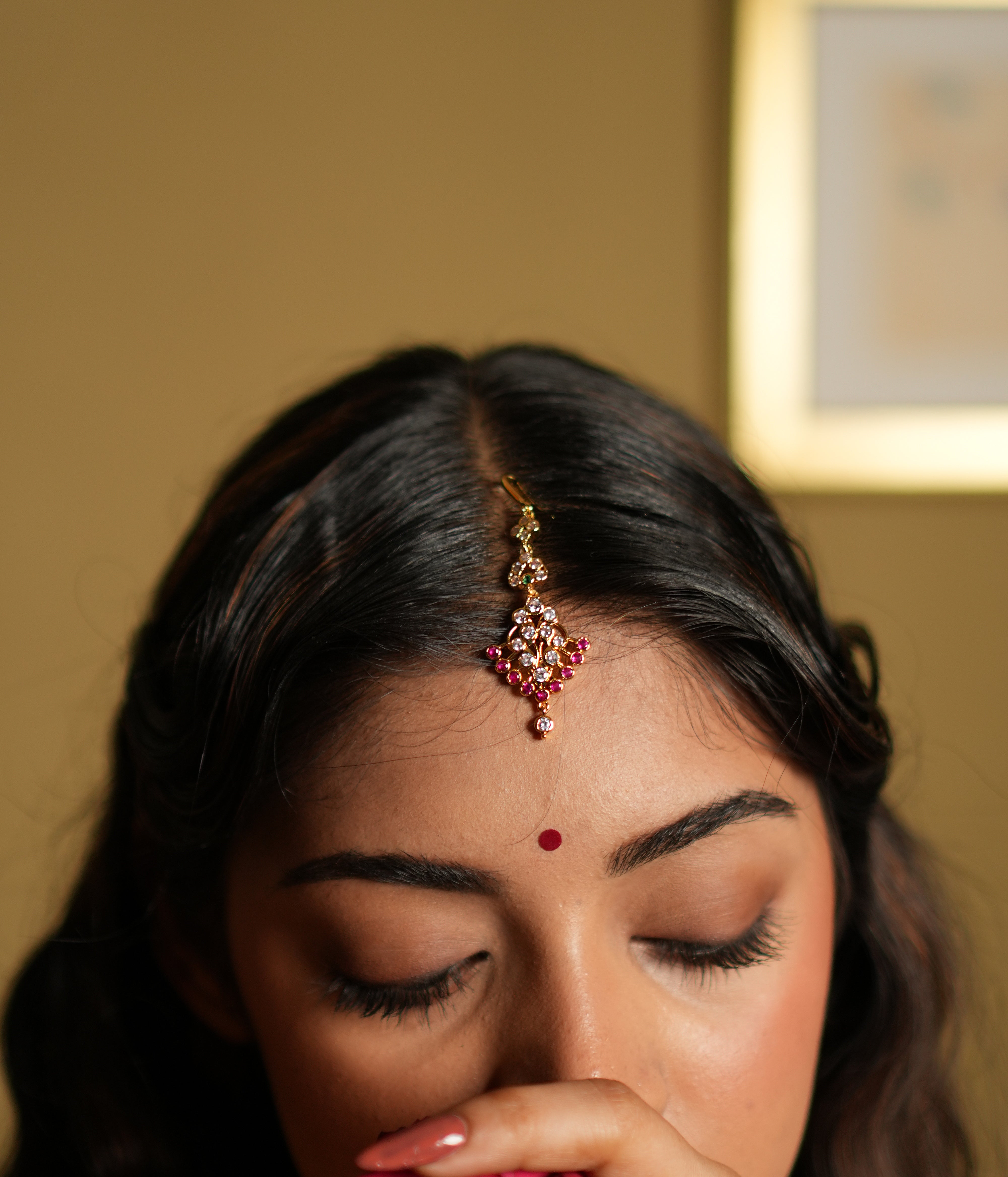  Maang Tikka, meticulously crafted from 92.5 sterling silver and finished with a rich 22-carat gold plating. The intricate design showcases a beautiful arrangement of vivid pink gemstones and sparkling white stones, creating a perfect balance of elegance and vibrancy. Ideal for weddings, festivals, and special occasions, this Maang Tikka gracefully enhances your forehead, adding a timeless charm to your look.