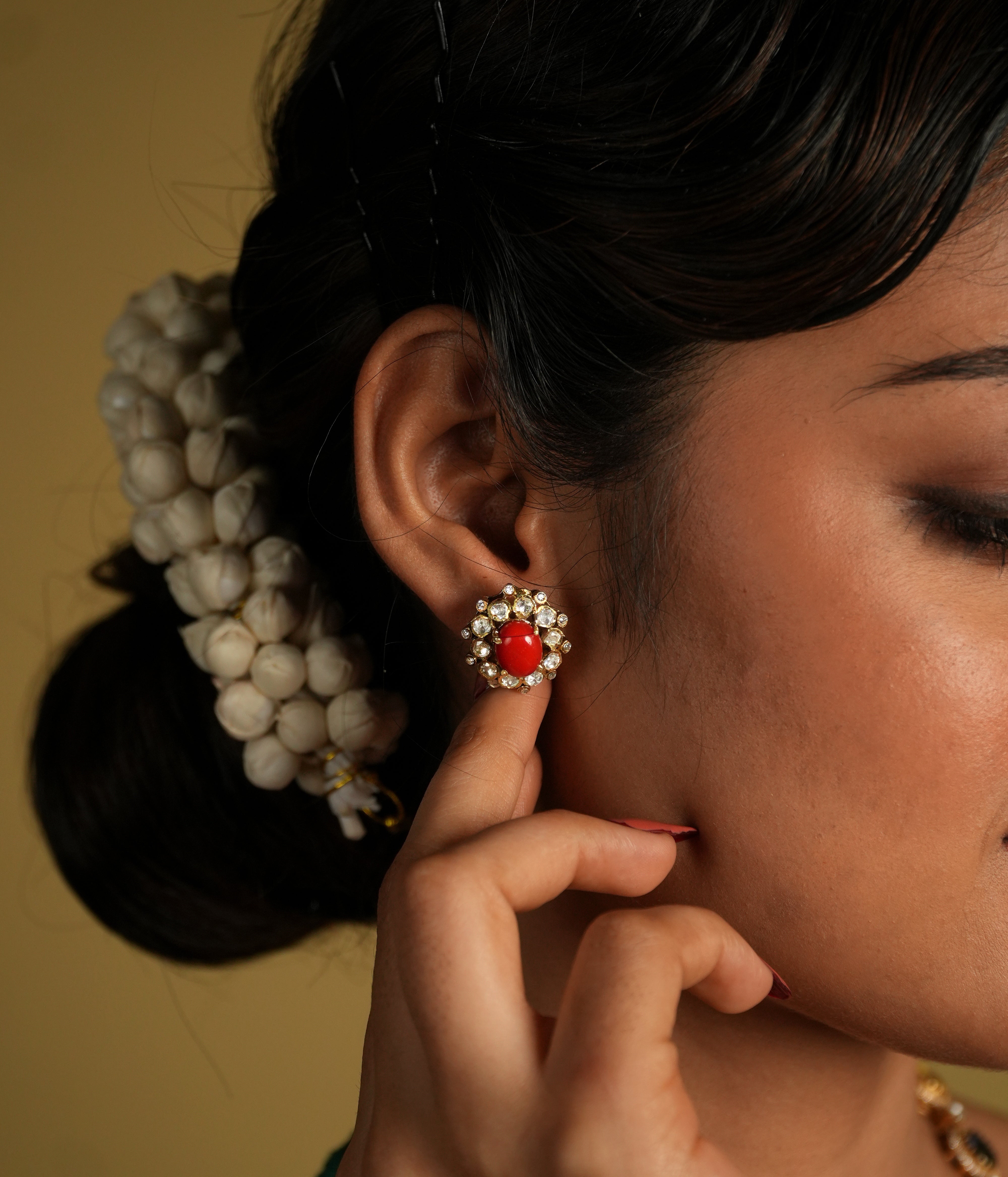 These delicate 92.5 sterling silver stud earrings showcase a vibrant coral gemstone at the center, surrounded by sparkling moissanite polkis that add a subtle yet elegant shine. The timeless design brings a perfect blend of tradition and sophistication.