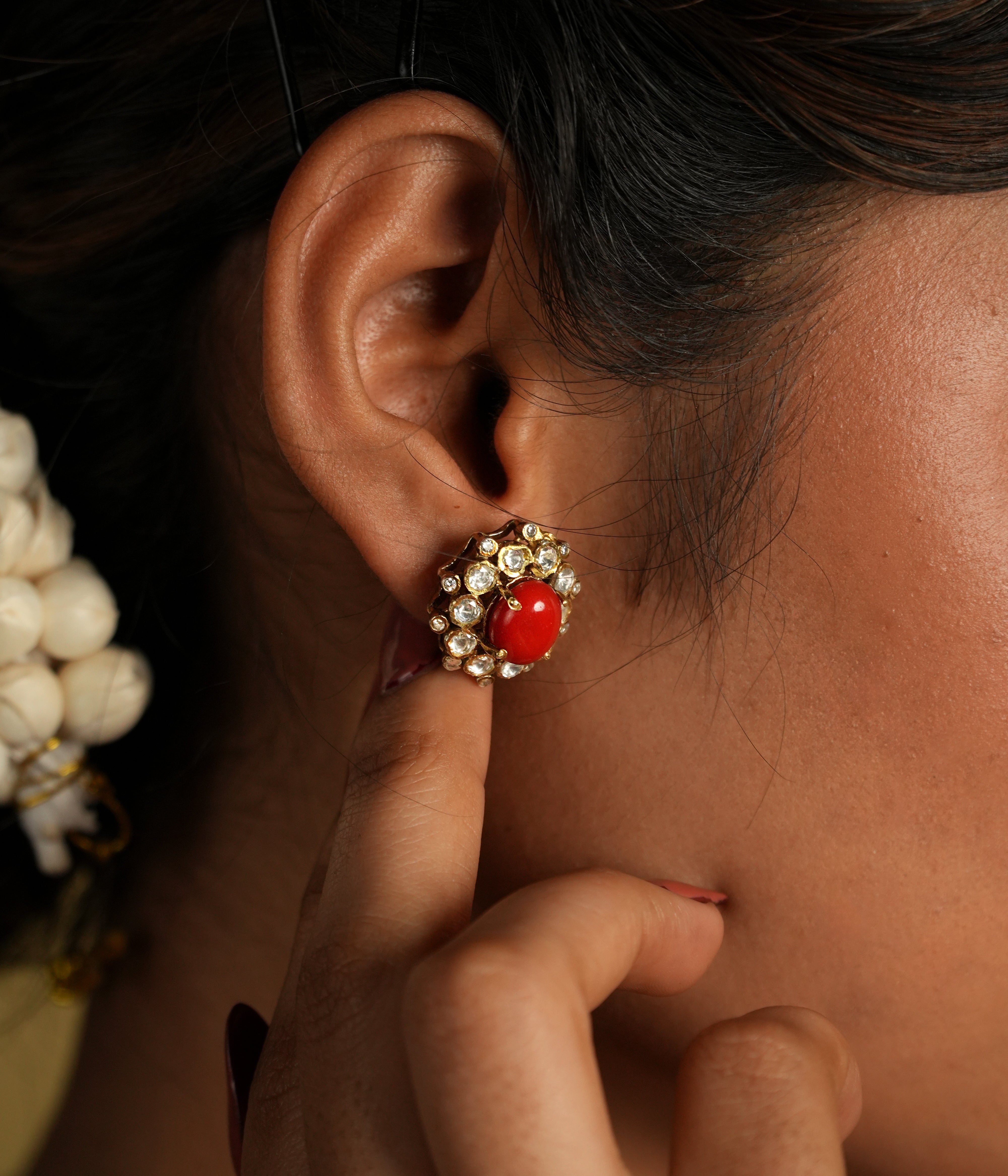 These delicate 92.5 sterling silver stud earrings showcase a vibrant coral gemstone at the center, surrounded by sparkling moissanite polkis that add a subtle yet elegant shine. The timeless design brings a perfect blend of tradition and sophistication.