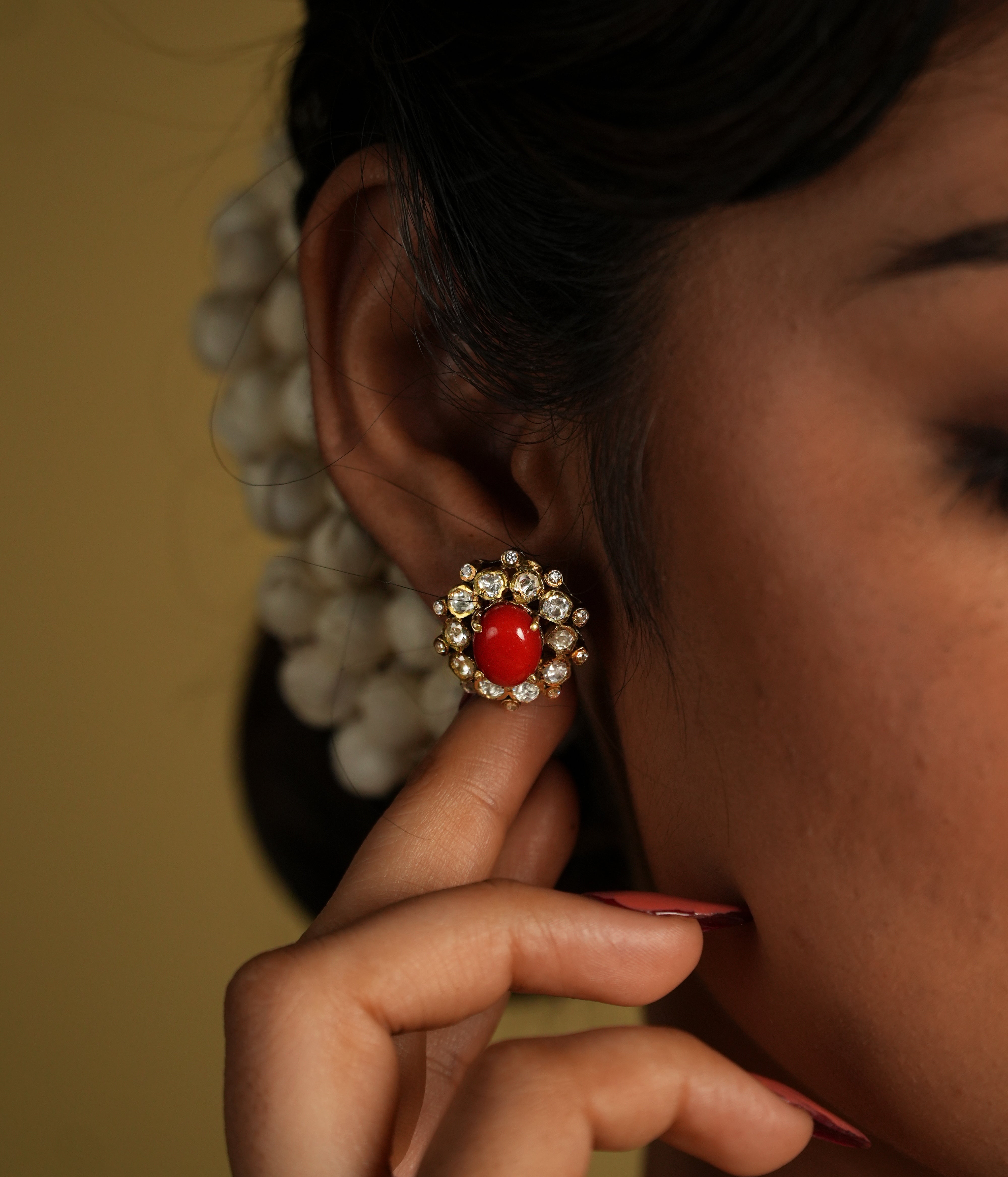 These delicate 92.5 sterling silver stud earrings showcase a vibrant coral gemstone at the center, surrounded by sparkling moissanite polkis that add a subtle yet elegant shine. The timeless design brings a perfect blend of tradition and sophistication.