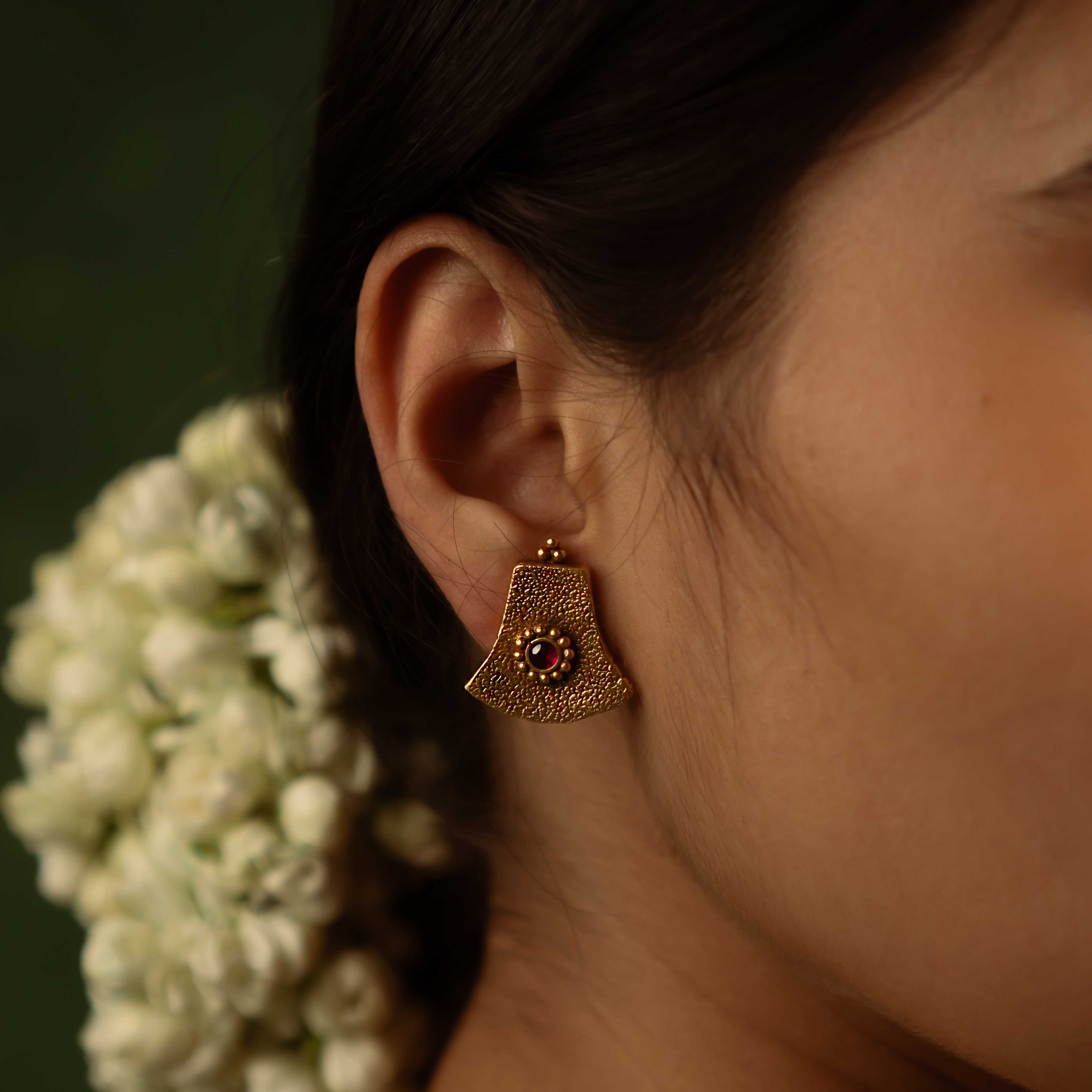 Ancient tales revived! The Peela-Kaner stud earrings (gold-plated silver) capture the essence of tribal heritage with their rich red spinel stones, delivering rustic elegance for the modern woman.