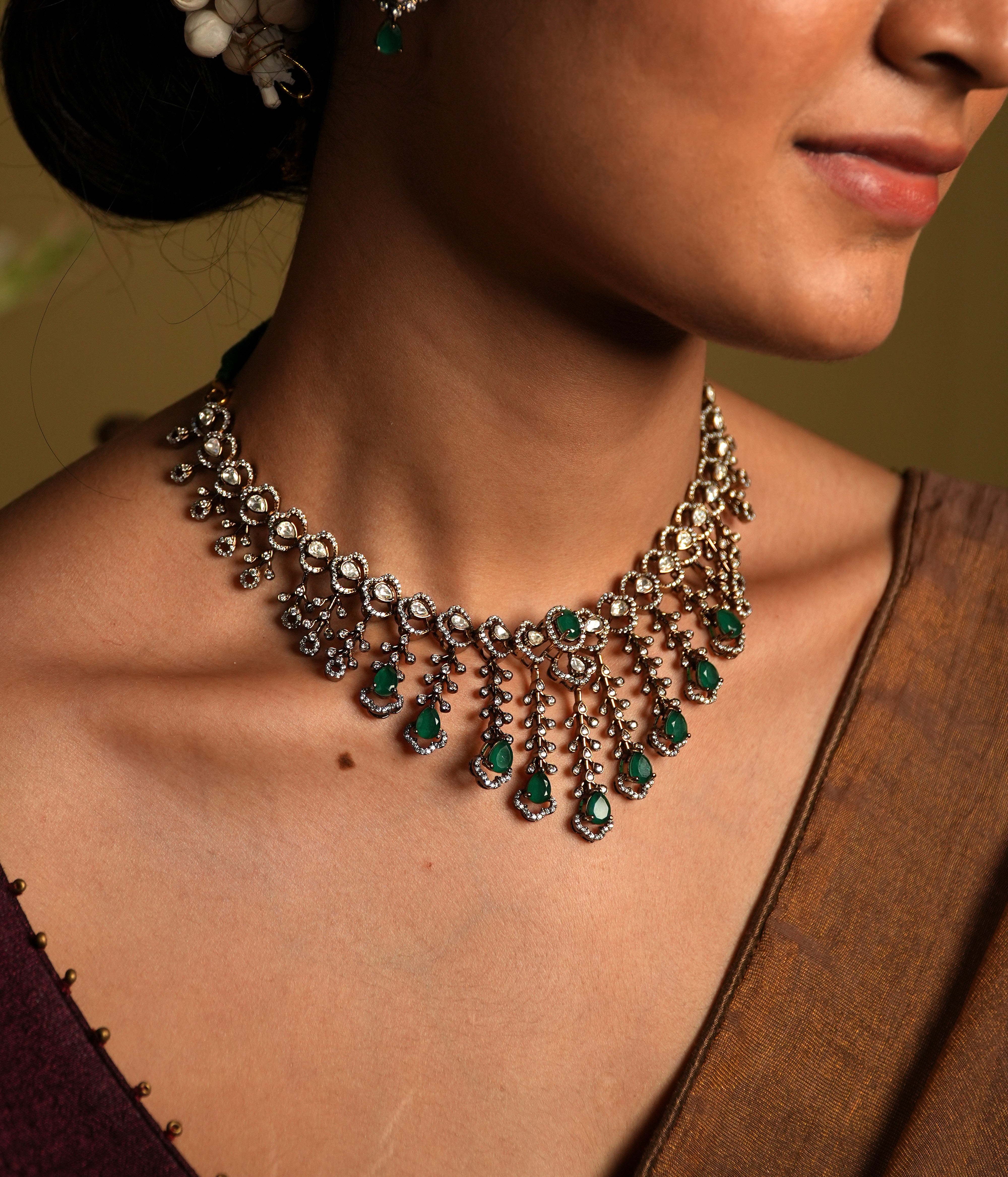 The combination of moissanite and cultured emerald in a Victorian choker, set in 925 silver and gold plating, offers a perfect blend of vintage elegance and modern luxury. Moissanite's fiery sparkle paired with the deep green glow of emerald creates a contrast that's both striking and captivating.