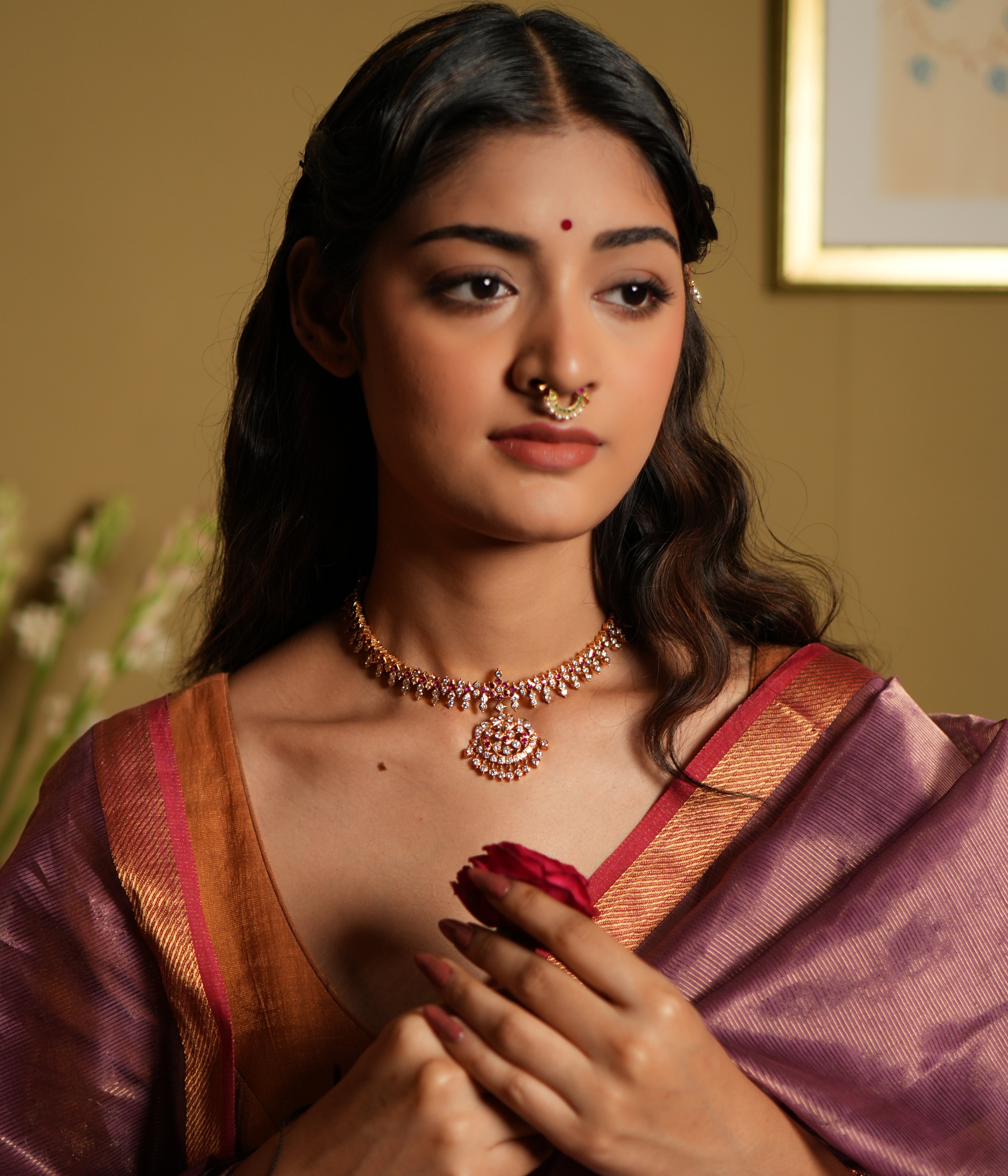 Elevate your traditional attire with this exquisite Attigai necklace, crafted from 92.5 sterling silver and finished with a rich 22-carat gold plating. Adorned with dazzling Swarovski crystals and accented with vivid pink gemstones, this necklace exudes timeless elegance and sophistication. 