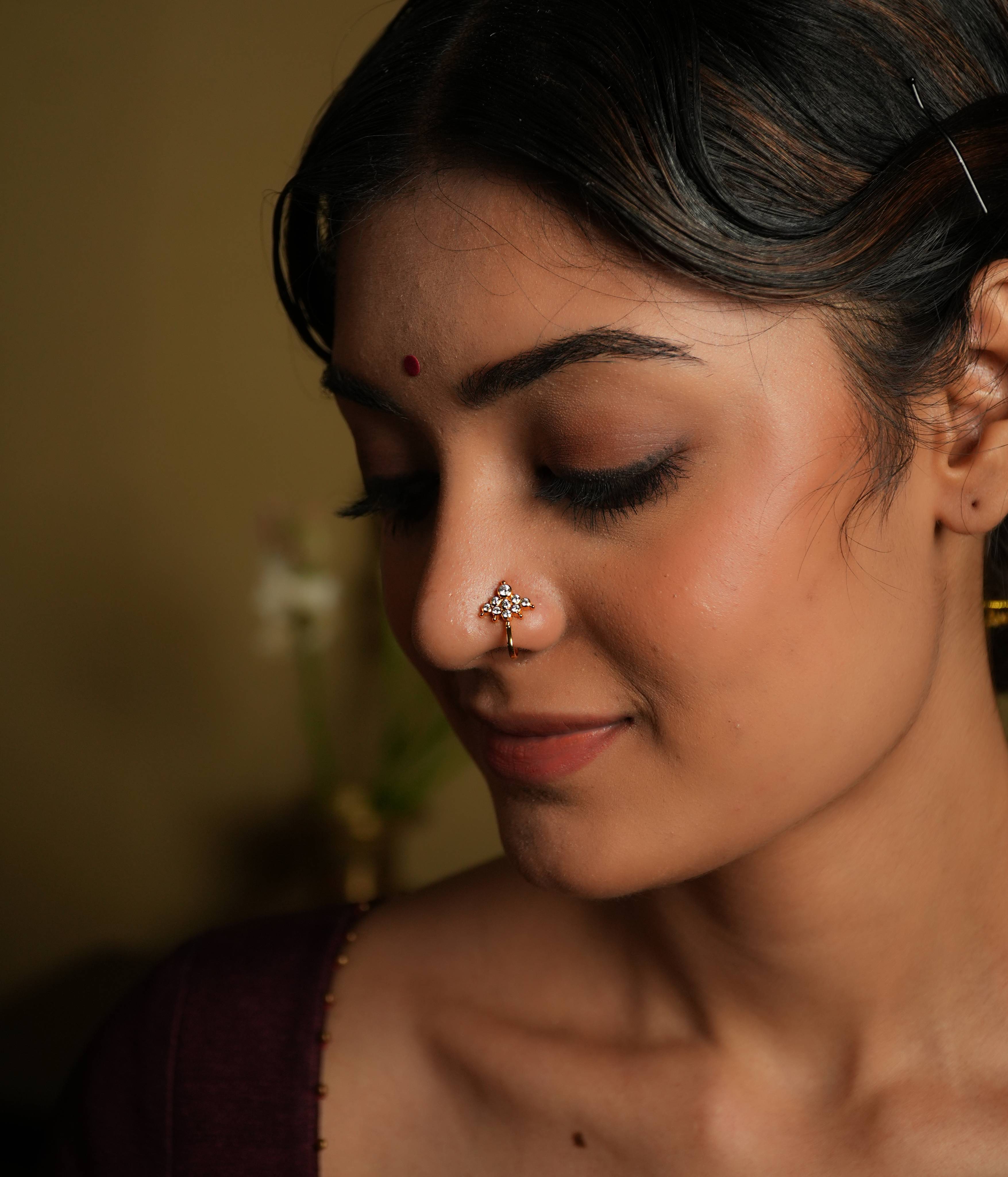 92.5 silver gold plated This minimal nose stud shines with modern elegance,
featuring moissanite set in geometric fashion. Inspired by vintage Chettinad stone setting, it
evokes the rich heritage of Indian craftsmanship. A tiny, timeless treasure that adds a touch
of subtle sophistication.