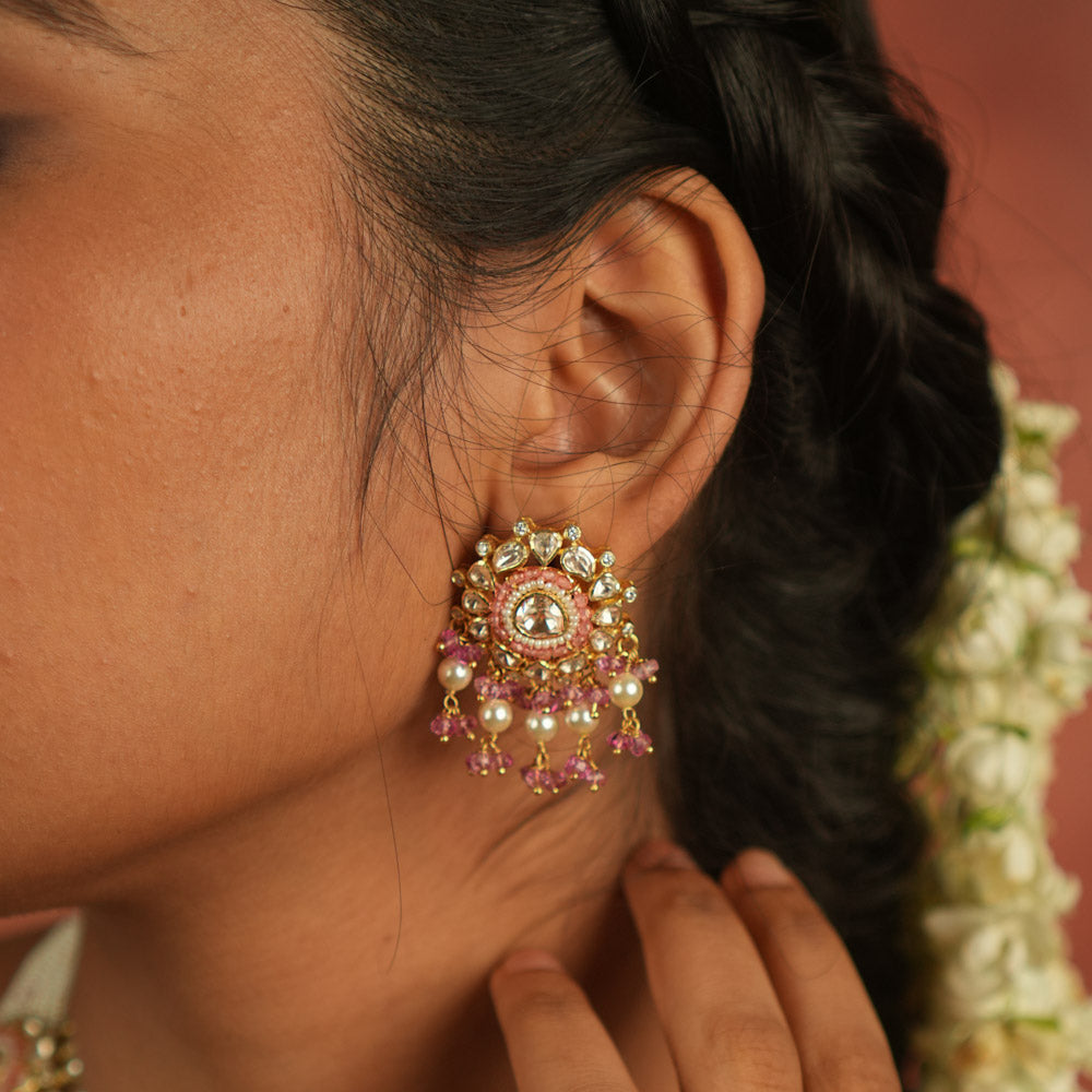 These exquisite dangler earrings, featuring Moissanite Polki stones, red beads, CZ stones, and pearls, offer a perfect balance of precision and elegance. Ideal for any occasion, they seamlessly complement both casual and formal attire.