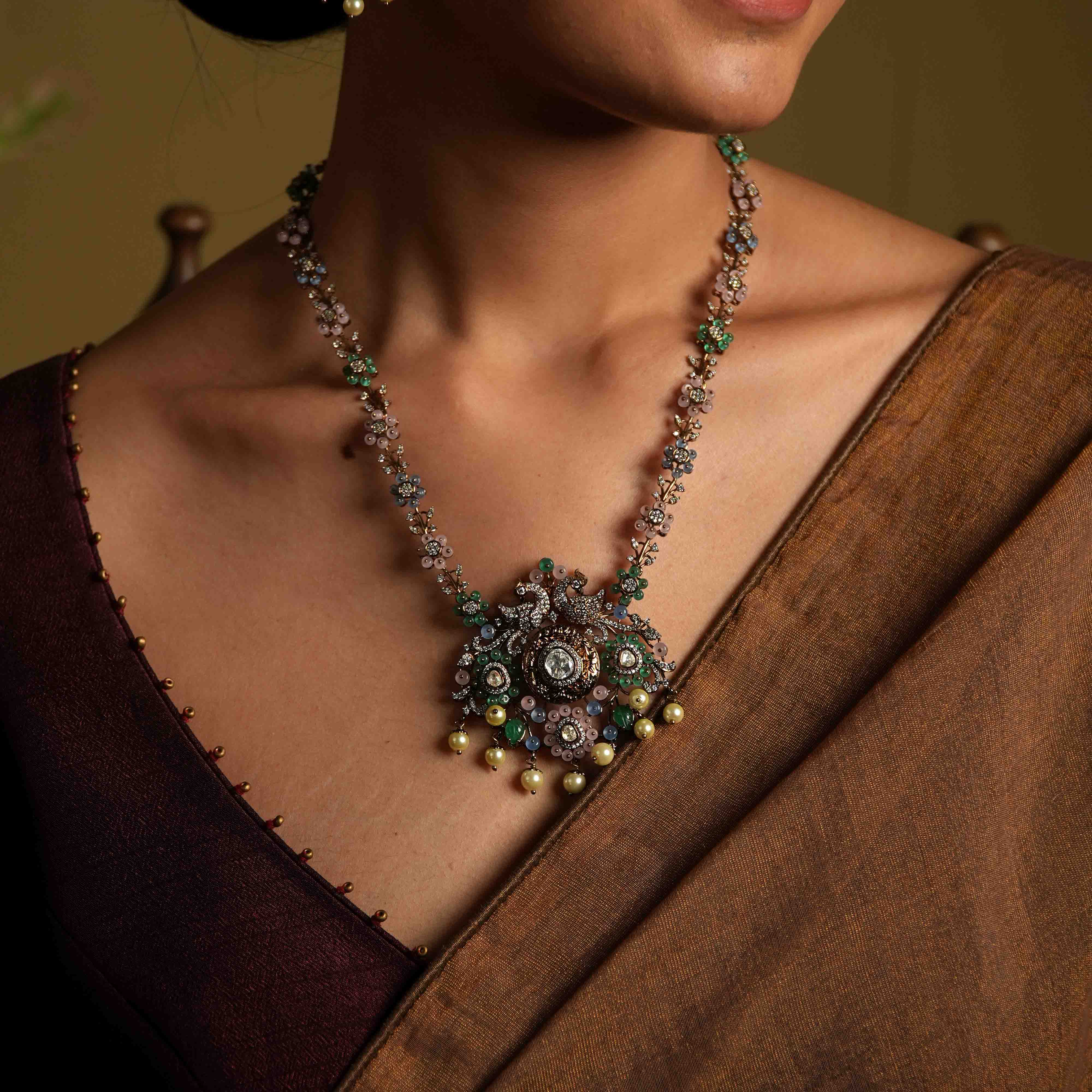 A handcrafted 92.5 sterling silver and 14ct dark antique gold-plated necklace, featuring CZ stones, polki stones, green beads, and pearls in a Victorian finish, showcasing intricate floral designs and a show-stopping double peacock moissanite pendant.