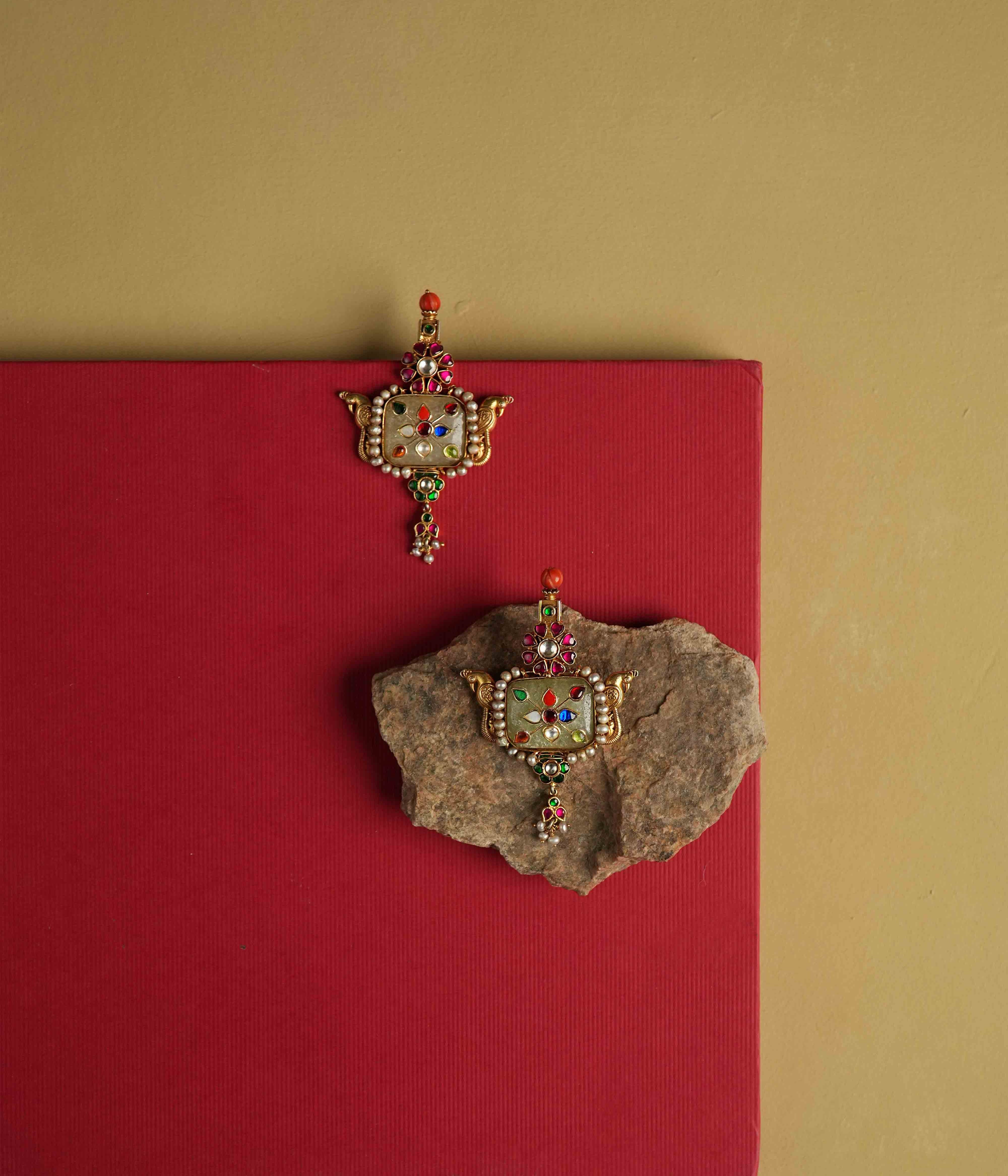 Elegant 92.5 sterling silver drop earrings featuring a bold natural gemstone. Intricate multi-colored meenakari engravings adorn the surface, reflecting the opulence of India's royal heritage. A stunning piece designed to make a statement.