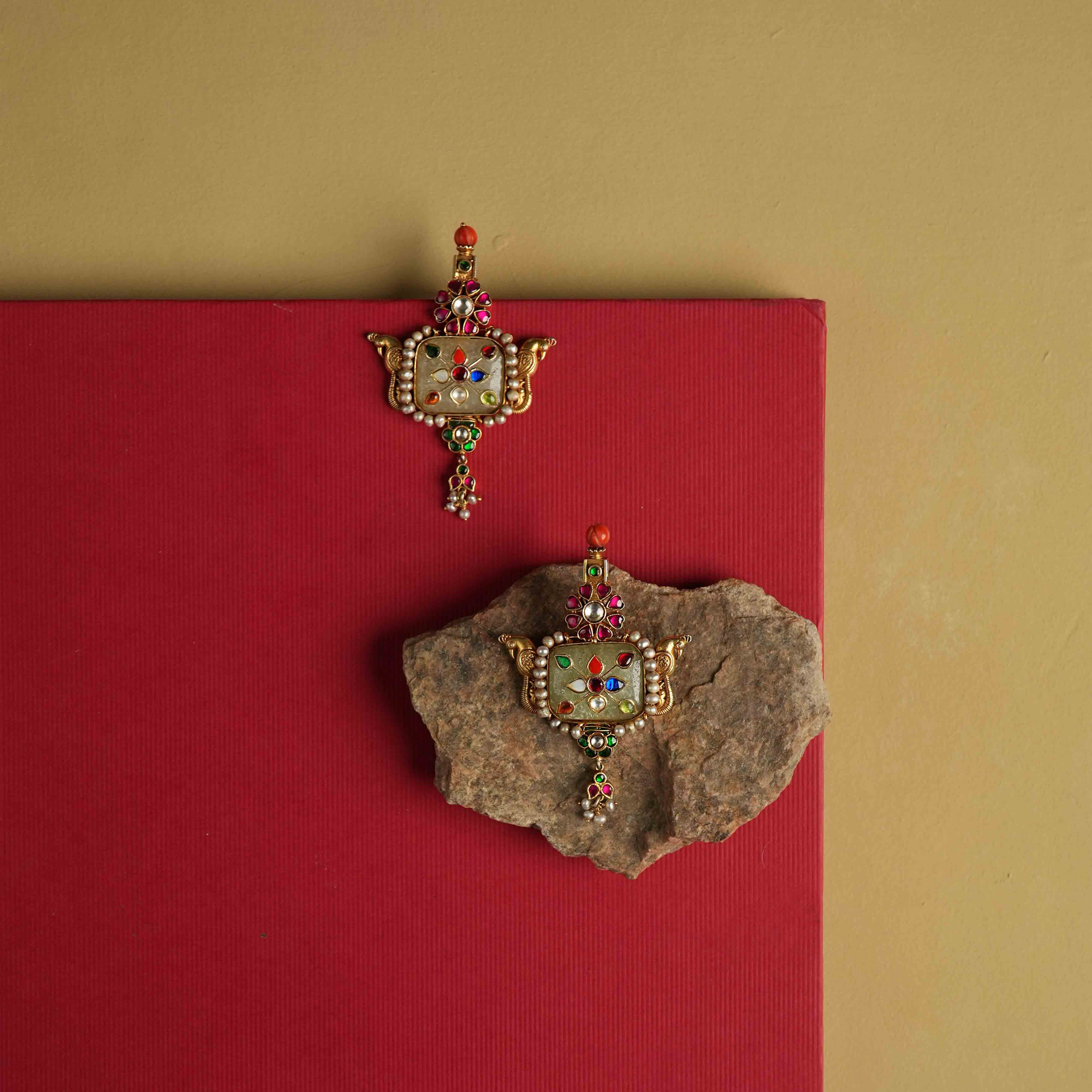 Elegant 92.5 sterling silver drop earrings featuring a bold natural gemstone. Intricate multi-colored meenakari engravings adorn the surface, reflecting the opulence of India's royal heritage. A stunning piece designed to make a statement.