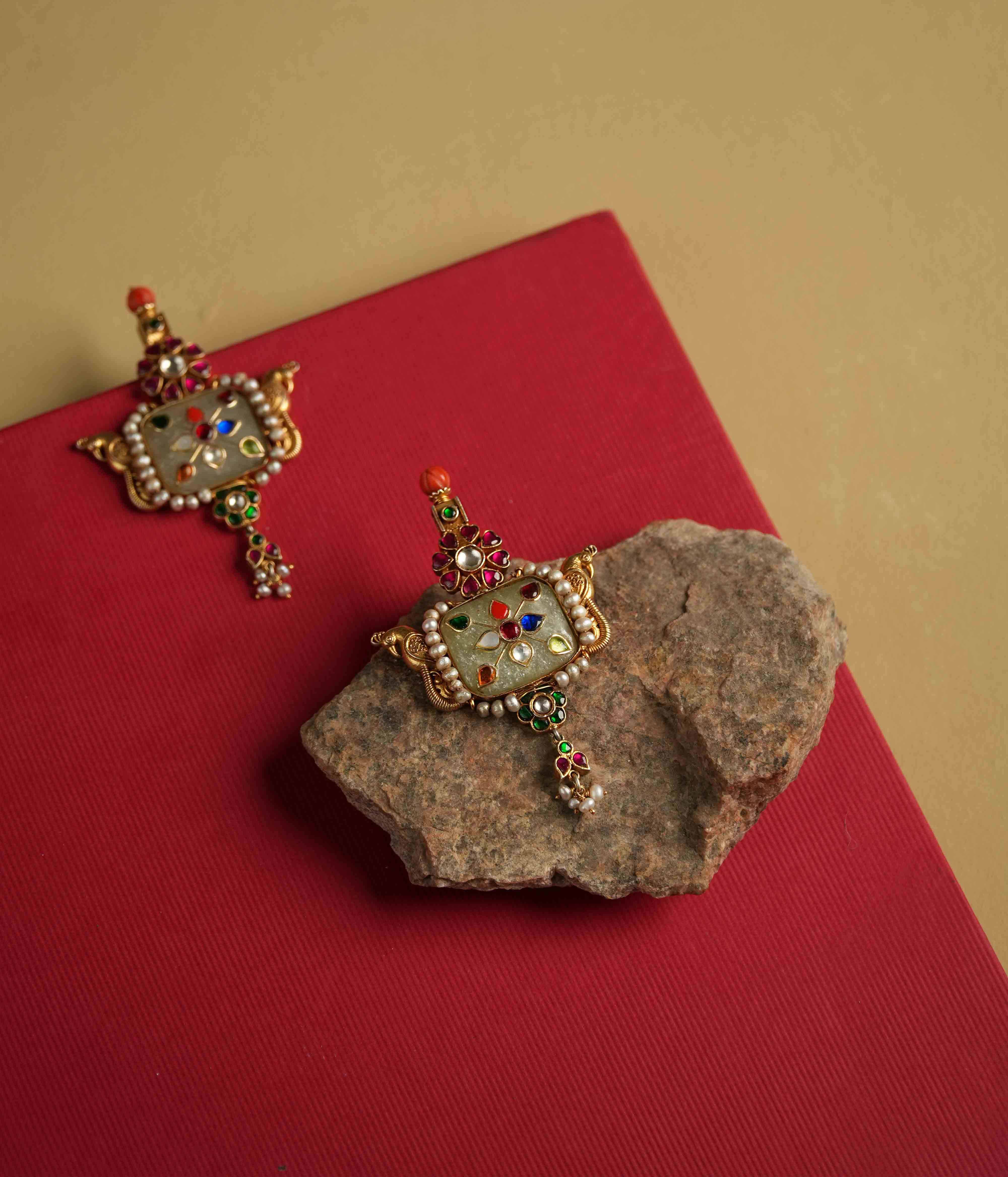 Elegant 92.5 sterling silver drop earrings featuring a bold natural gemstone. Intricate multi-colored meenakari engravings adorn the surface, reflecting the opulence of India's royal heritage. A stunning piece designed to make a statement.