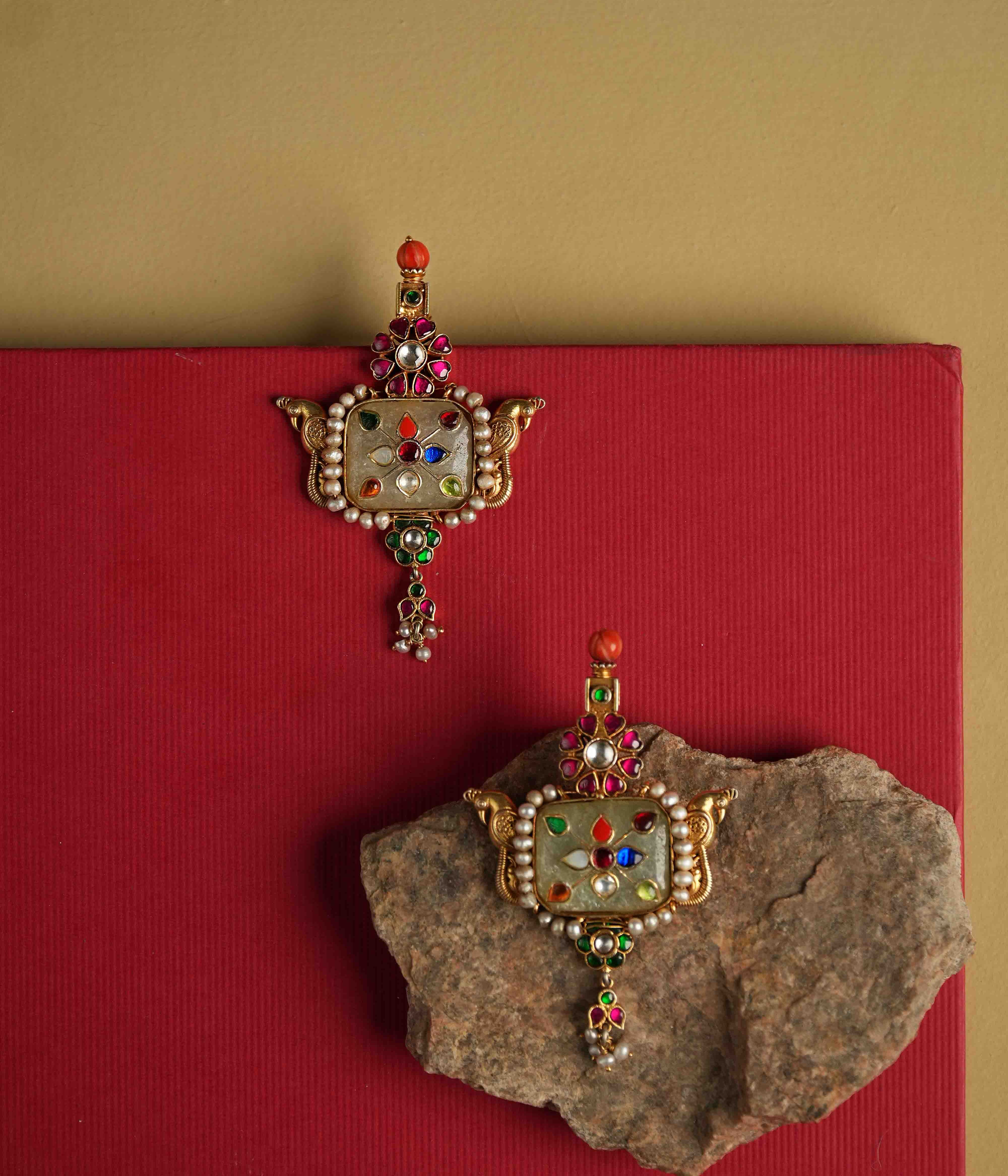 Elegant 92.5 sterling silver drop earrings featuring a bold natural gemstone. Intricate multi-colored meenakari engravings adorn the surface, reflecting the opulence of India's royal heritage. A stunning piece designed to make a statement.