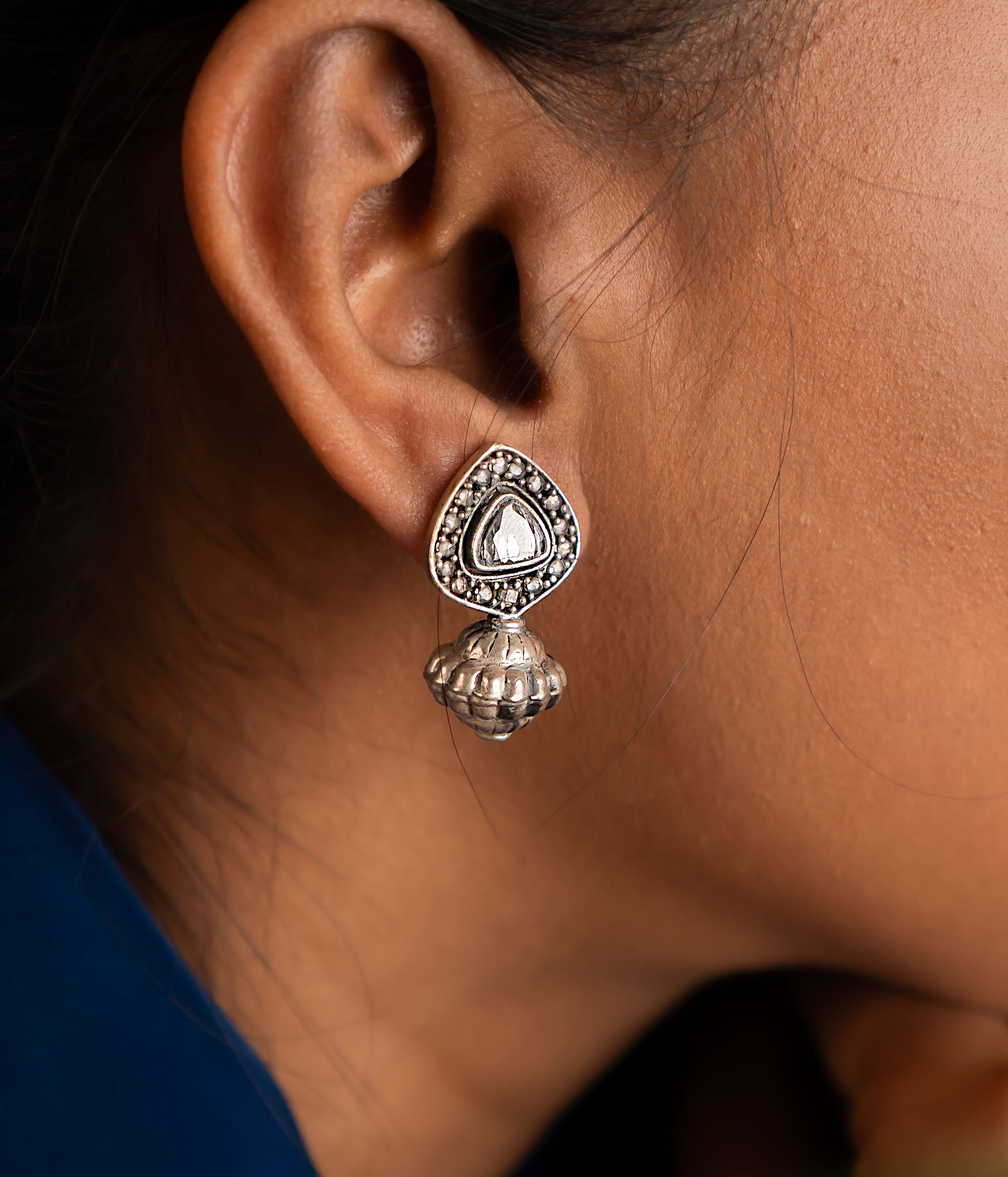 These jhumka earrings feature intricately cut polkis at the center, with a gracefully suspended dome, creating a unique and timeless design.