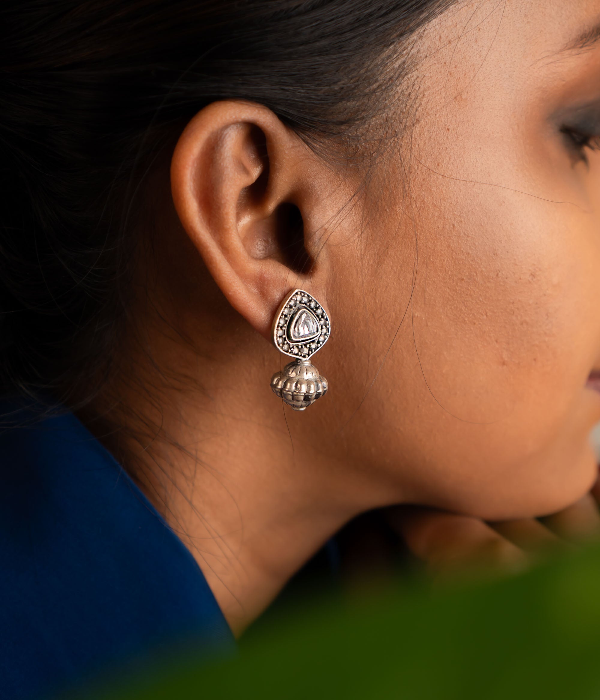 These jhumka earrings feature intricately cut polkis at the center, with a gracefully suspended dome, creating a unique and timeless design.