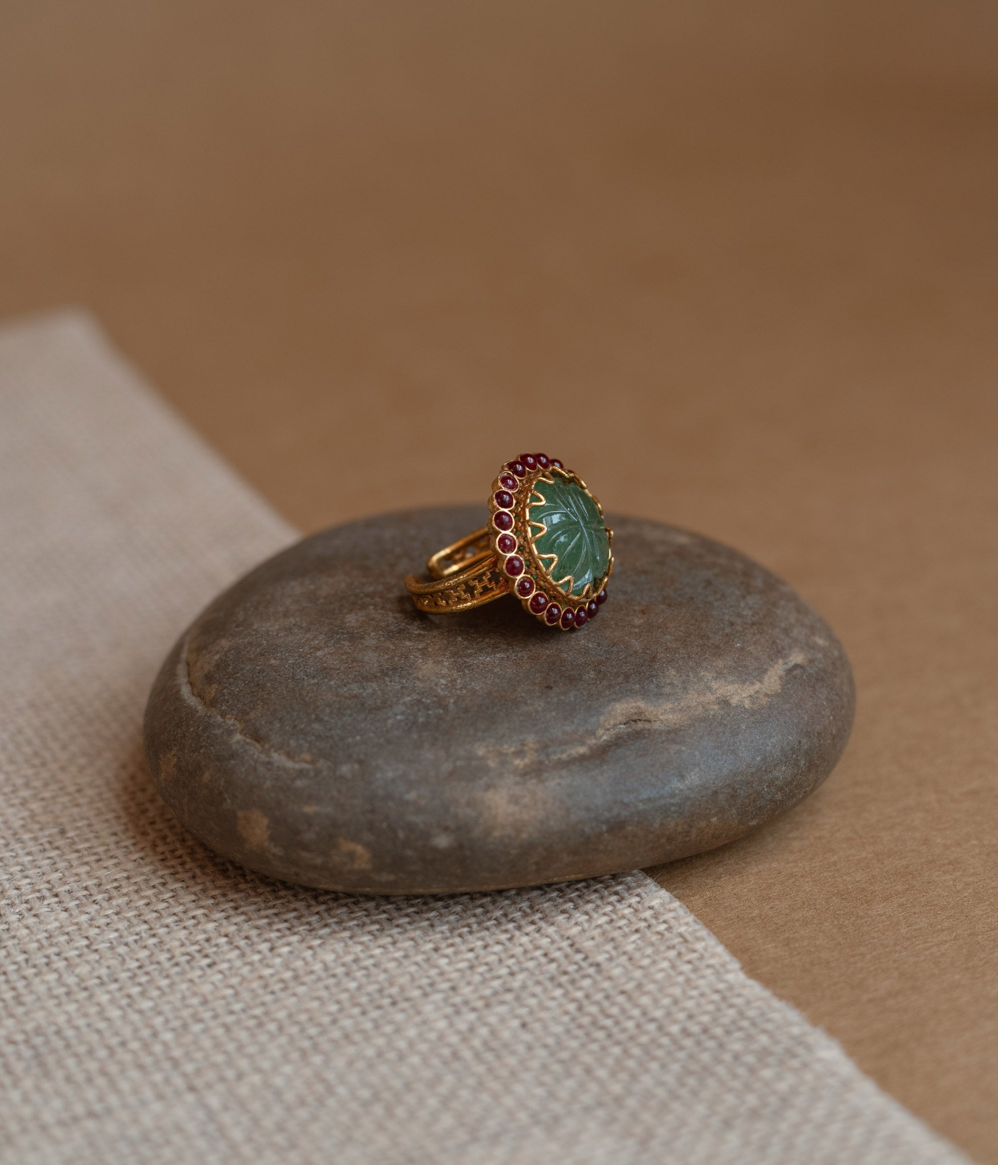 Temple collection ring with green Spinal and white Polki stones in traditional design.