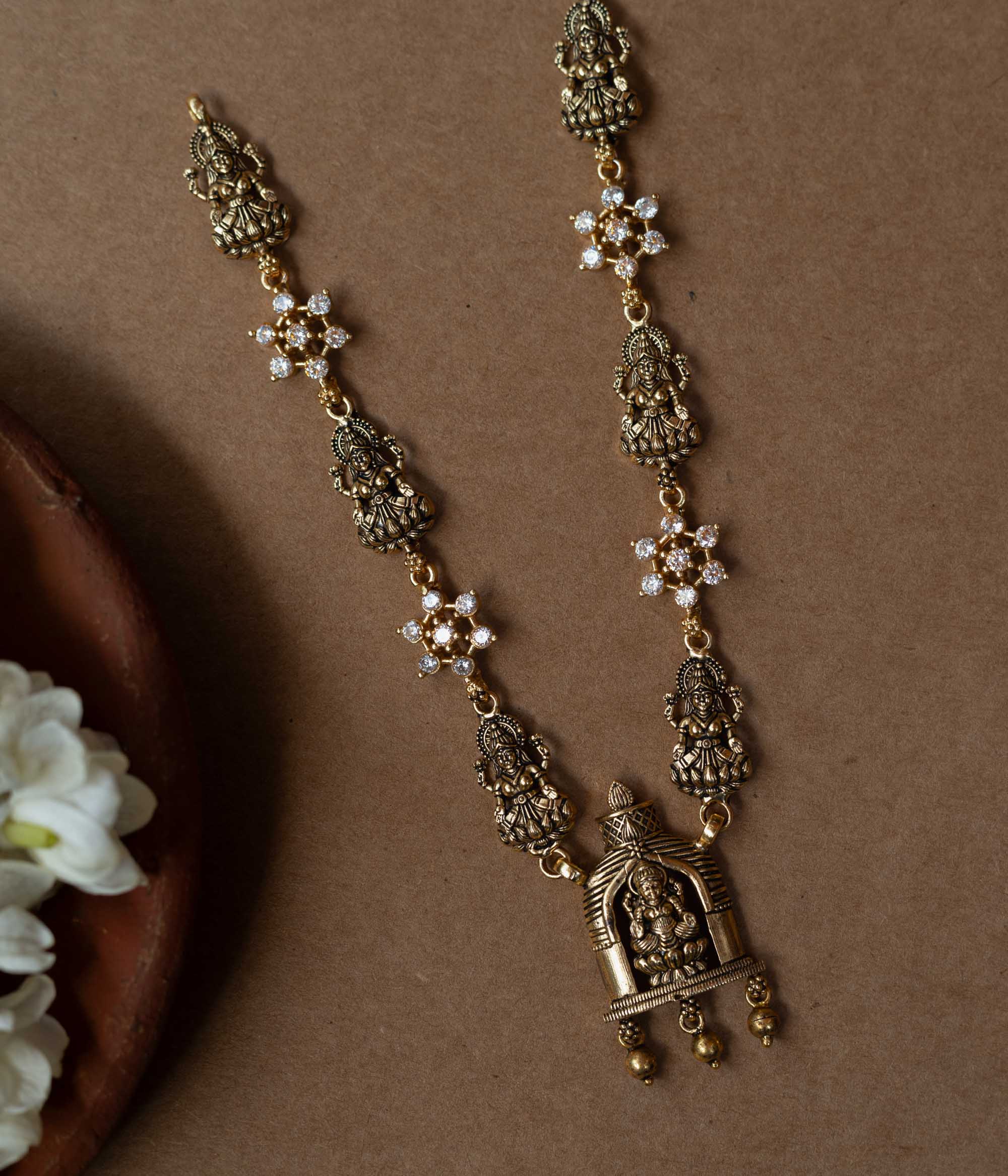 A 92.5 sterling silver Gauri Temple Pendant Necklace, featuring antique-finish Lakshmi motifs, floral crystal links, and a central temple pendant, invoking divine elegance for festive and traditional celebrations.
